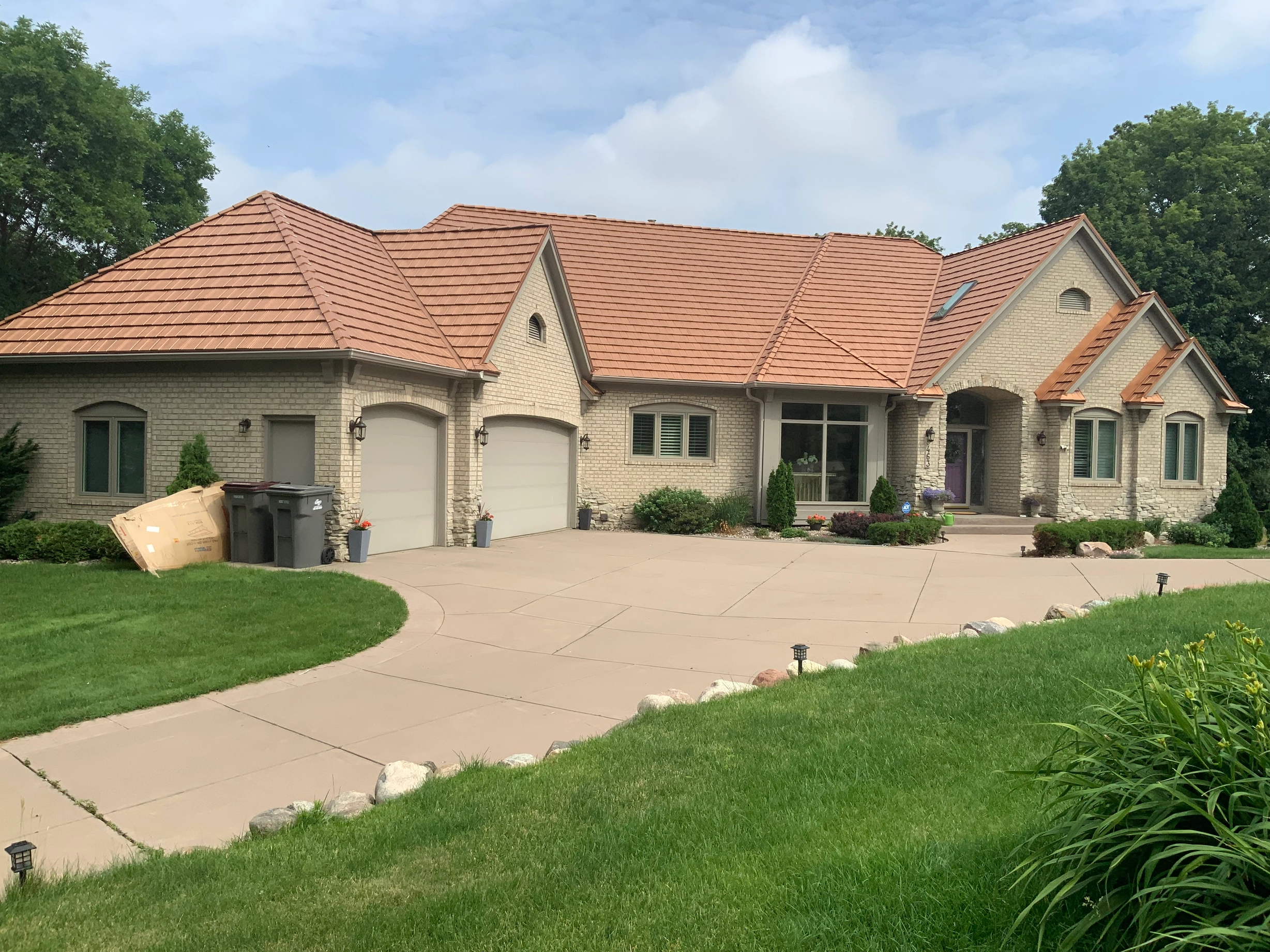 Aged Copper Interlock Shake aluminum roof on a beige one-storey home with a metal roof and a lawn, Eden Prairie, Minnesota