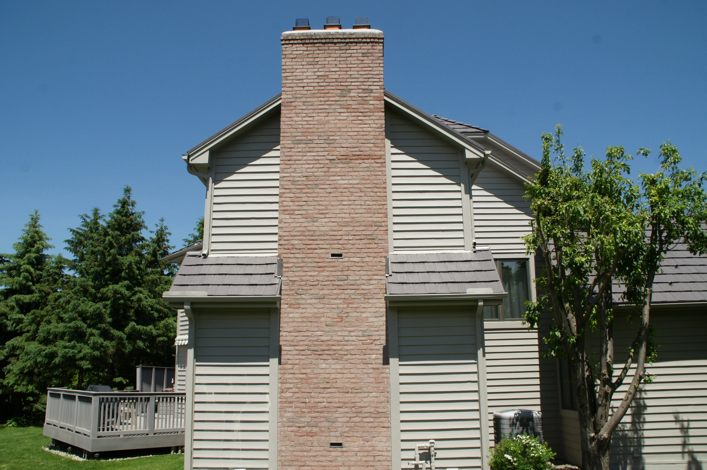 Weathered Interlock Shake aluminum roof on a white home with a metal roof and a tree in a suburban, Mendota Heights, Minnesota