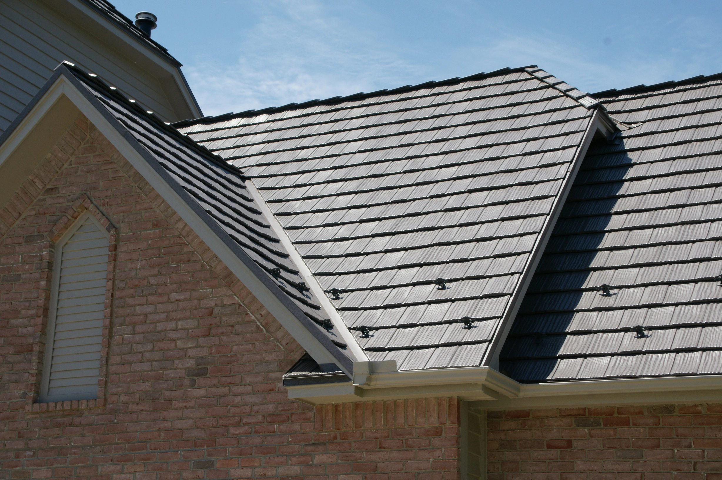 Weathered Interlock Shake aluminum roof on a tan brick home with a grey metal roof in a suburban, Mendota Heights, Minnesota