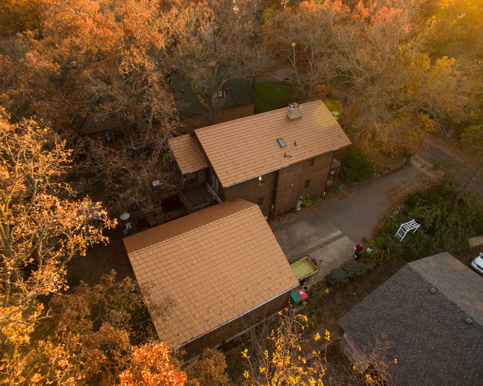 Aged Copper Interlock Shake aluminum roof on a brown ranch home with a metal roof among autumn trees, Bloomington, Minnesota