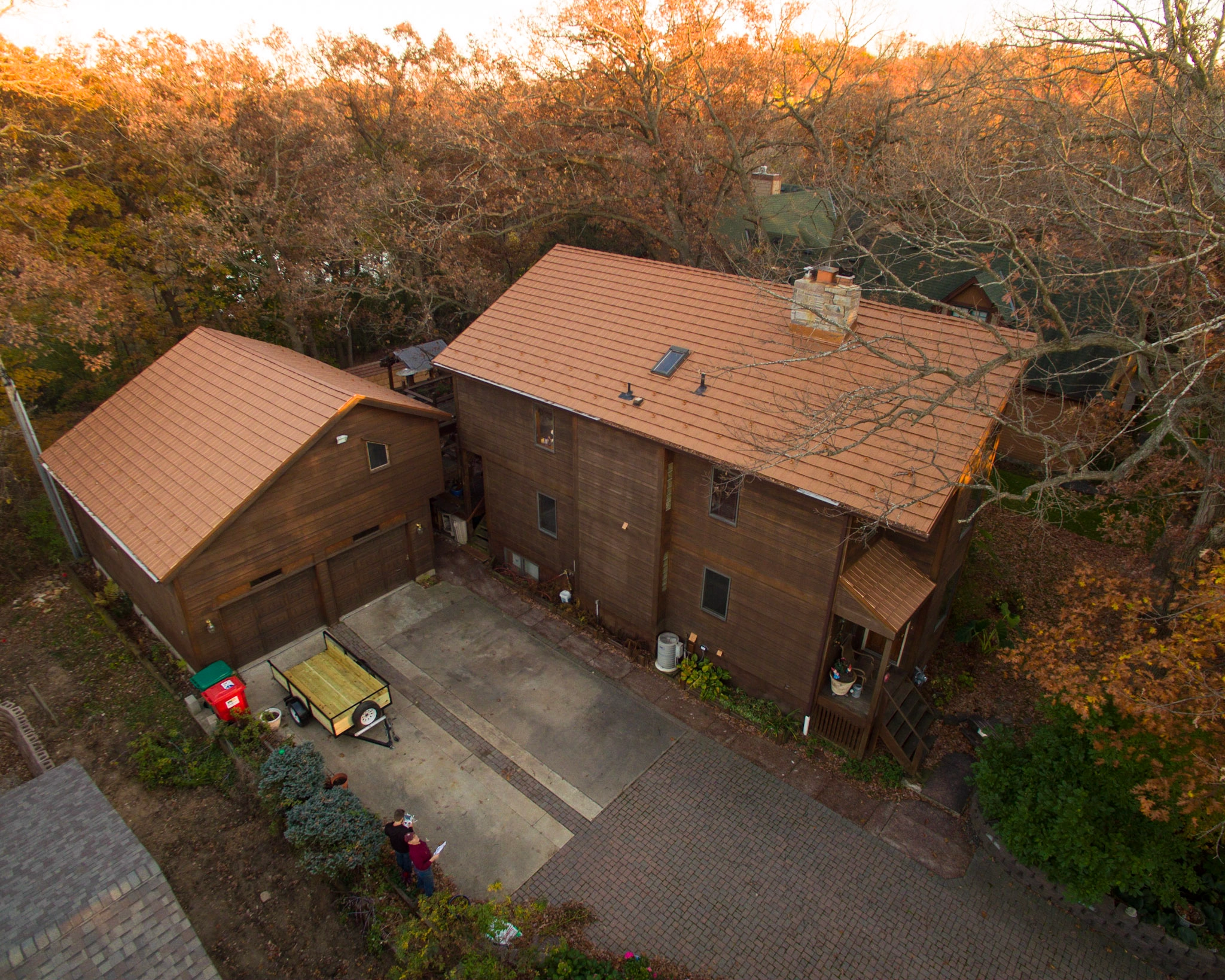 Aged Copper Interlock Shake aluminum roof on a brown single-storey ranch home among tall trees, Bloomington, Minnesota