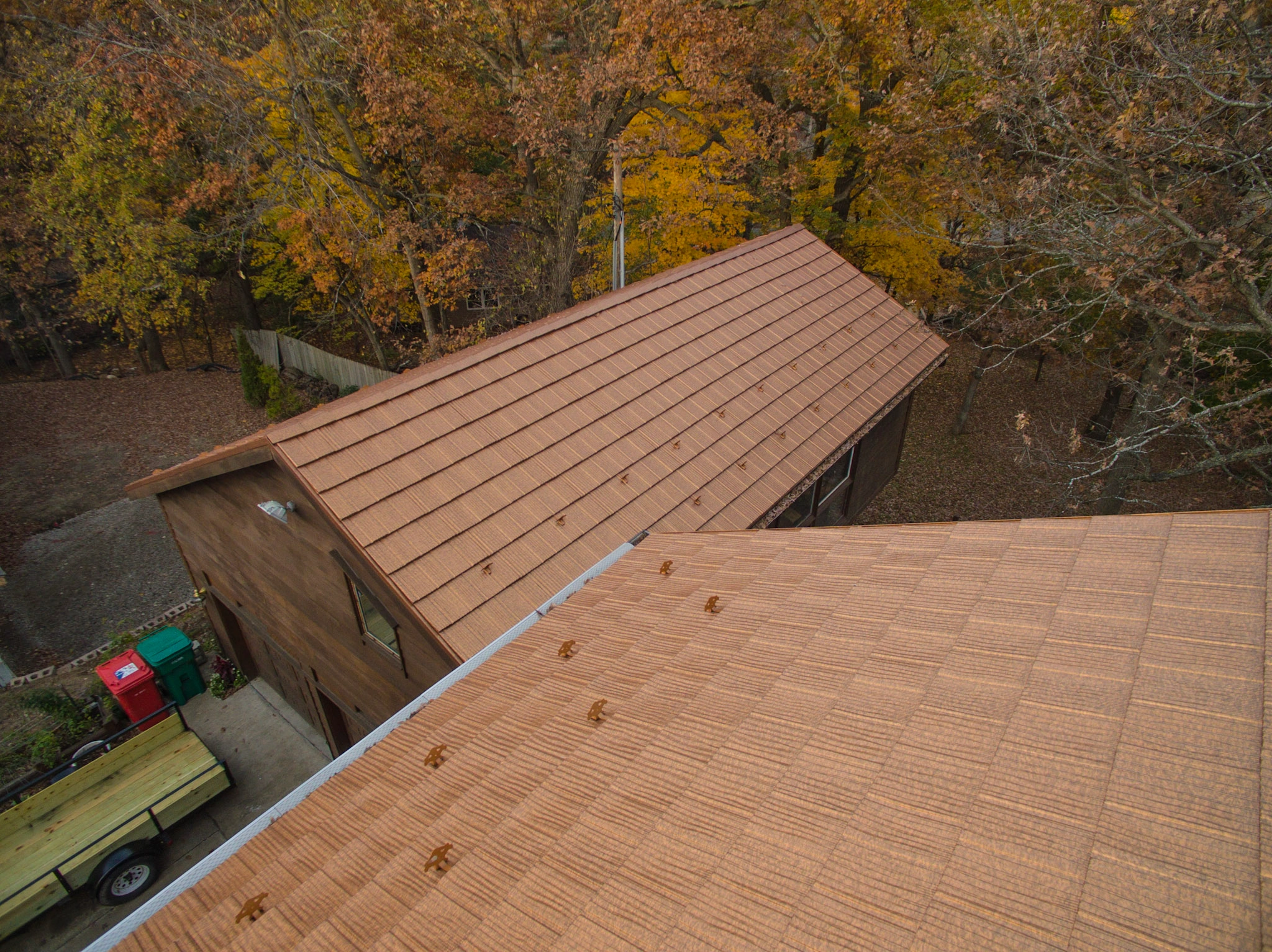 Aged Copper Interlock Shake aluminum roof on a brown single-family home with a metal roof in a forested, Bloomington, Minnesota