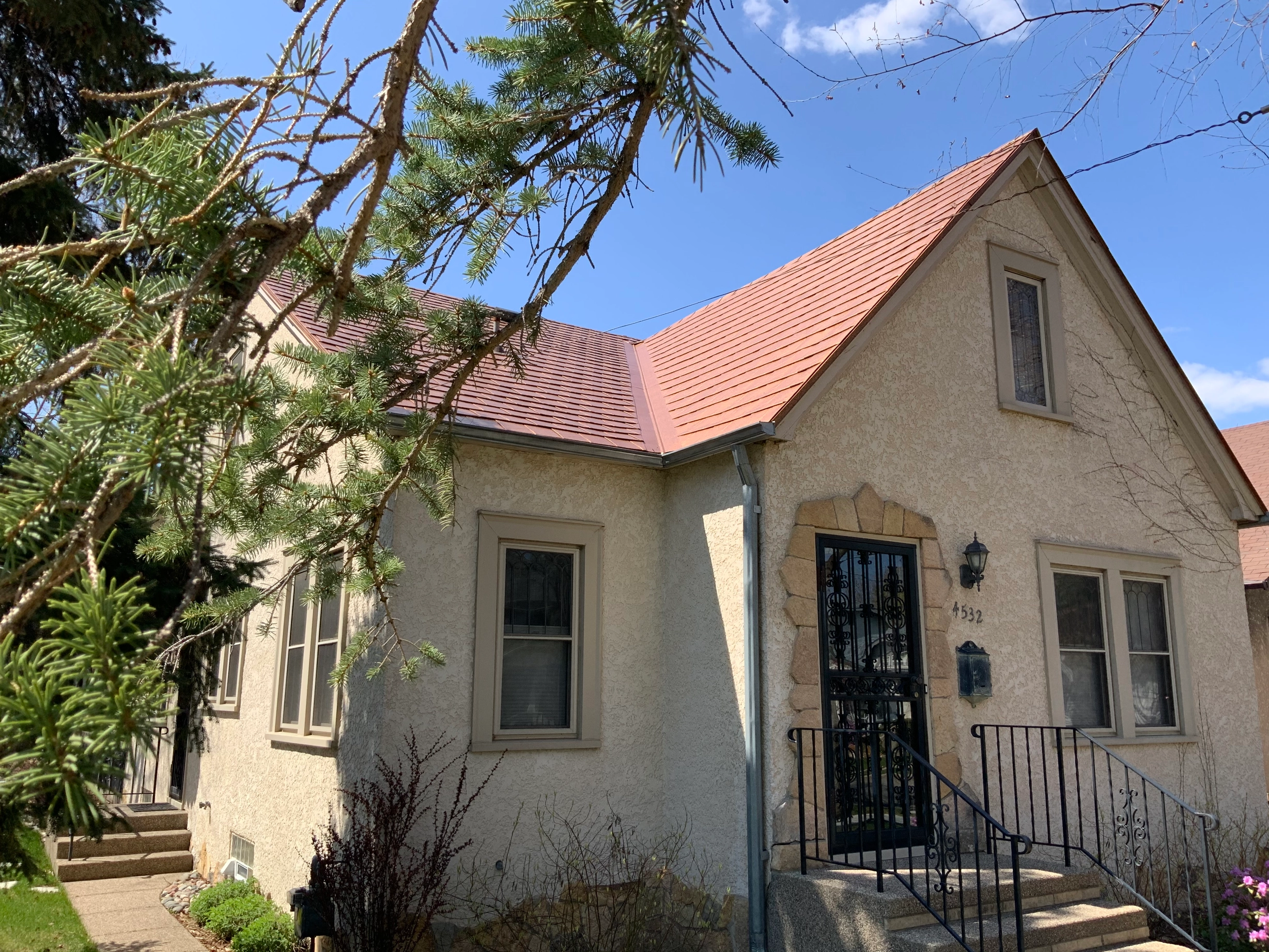 Aged Copper Interlock Slate aluminum roof on a cottage-style home with a red roof and a small front porch, Minneapolis, Minnesota