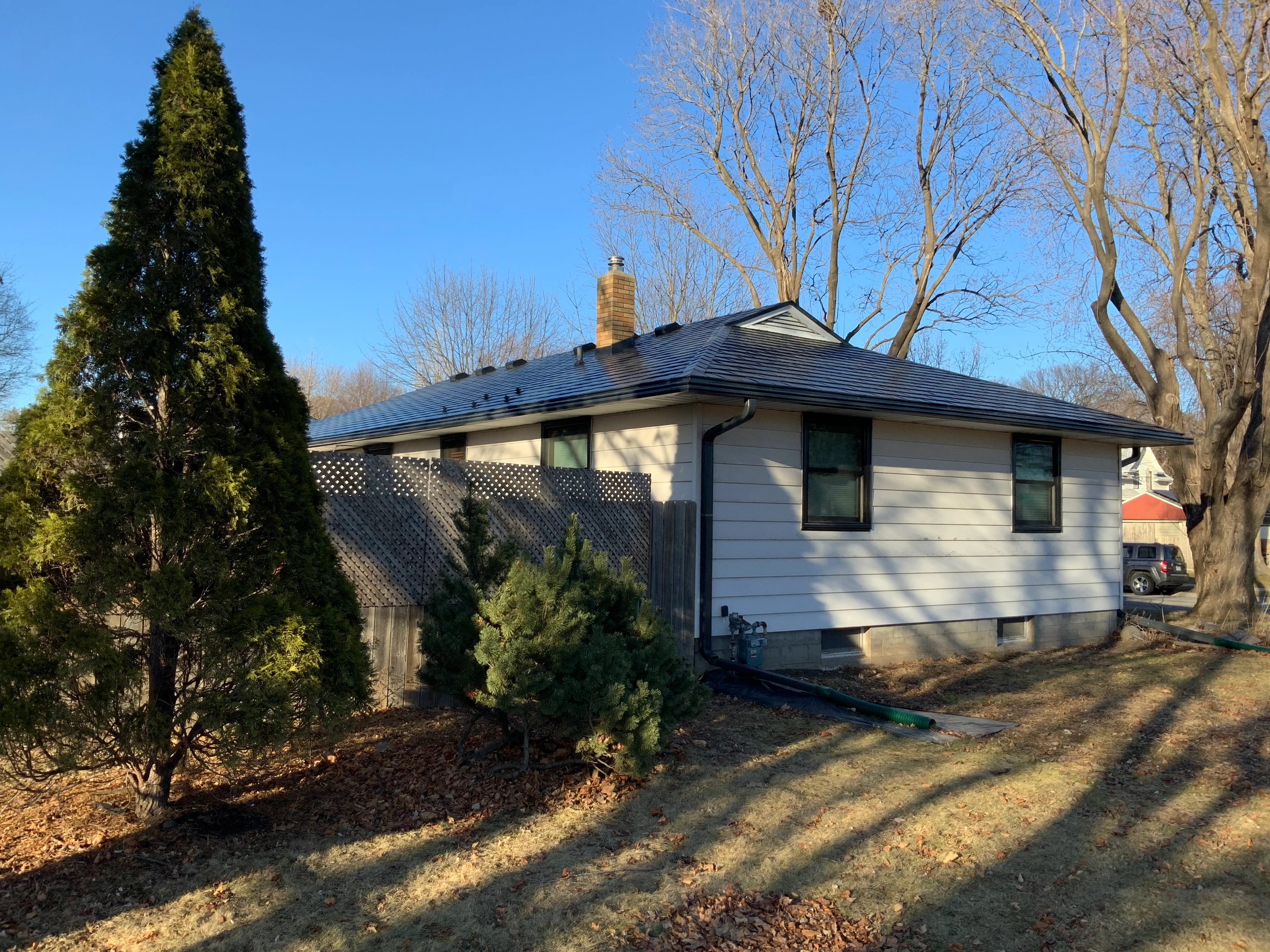 Black Interlock Slate aluminum roof on a beige single-family home with a metal roof in a suburban, St Paul, Minnesota