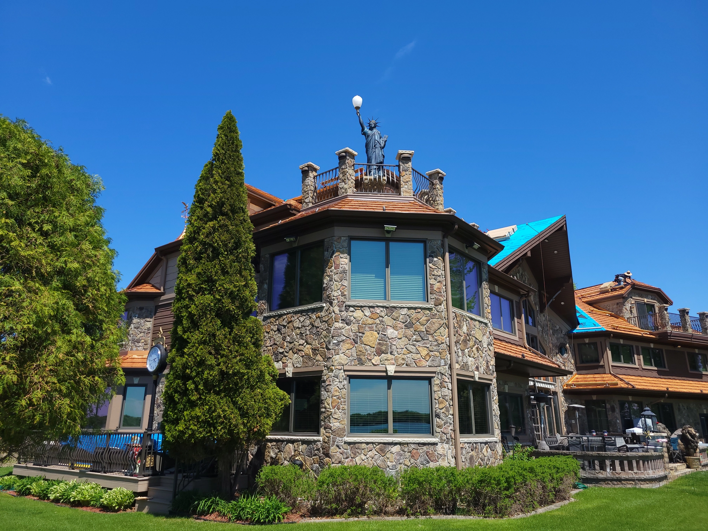 Copper Penny Interlock Shake aluminum roof on a stone ranch home with dormers on a lakeside lot, Mound, Minnesota
