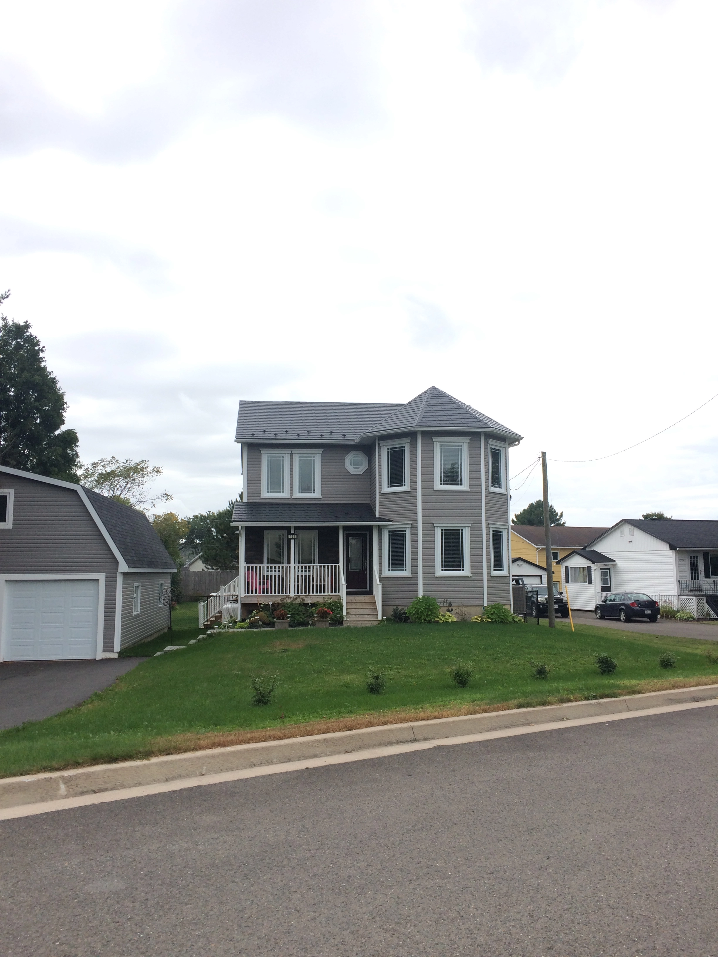 Black Interlock Slate aluminum roof on a grey two-storey home with a metal roof under construction, Fredericton, New Brunswick