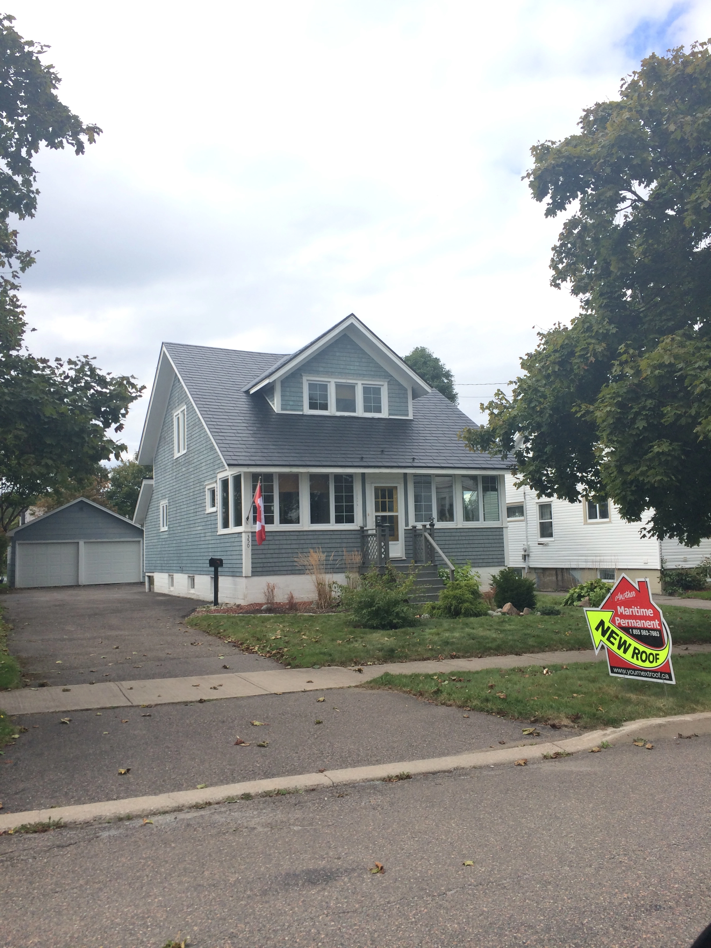 Black Interlock Slate aluminum roof on a grey two-storey Cape Cod with dormers in a suburban, Saint John, New Brunswick
