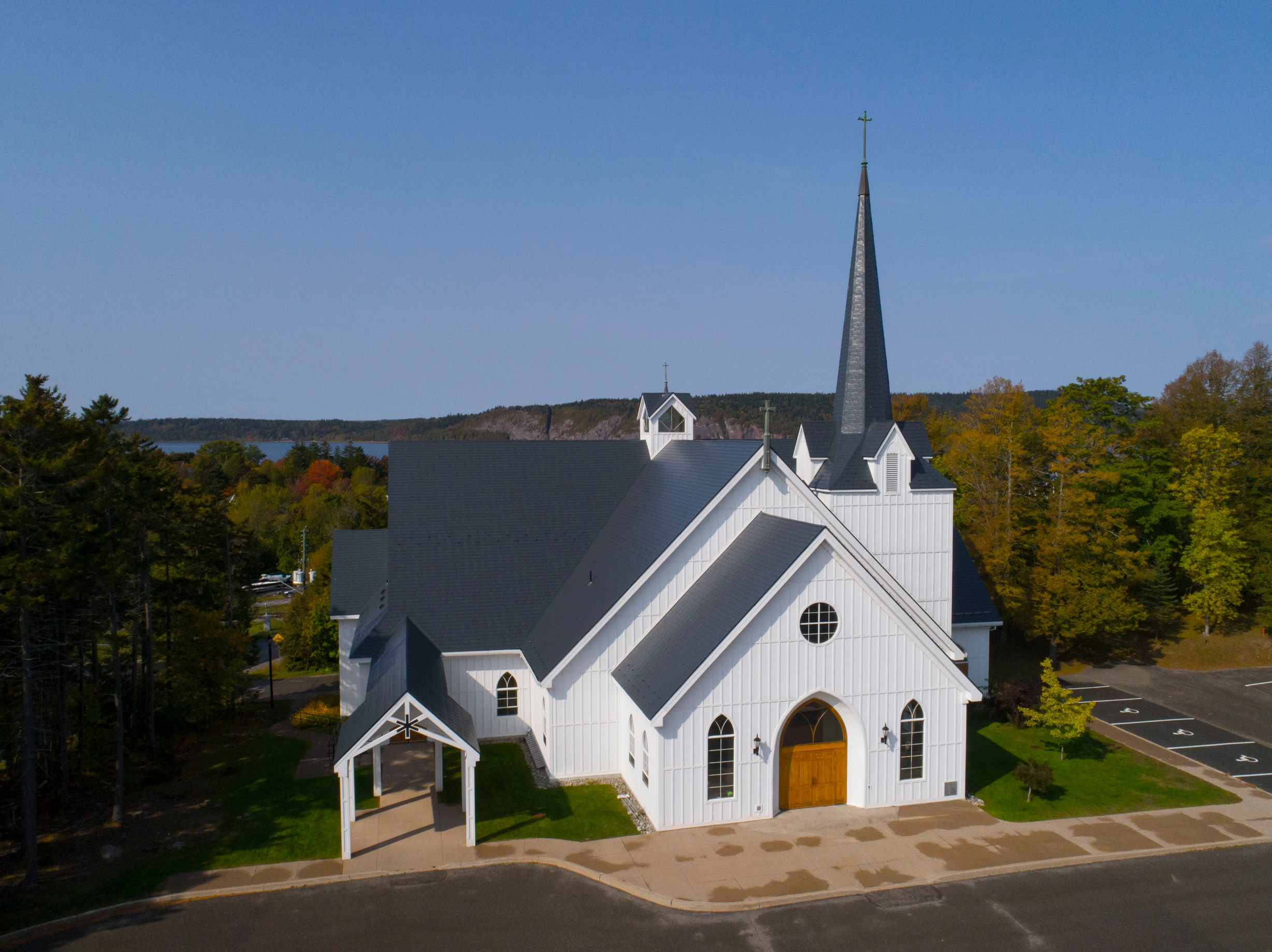 Deep Charcoal Interlock Slate aluminum roof on a white church with a metal roof among tall green trees, Rothesay, New Brunswick