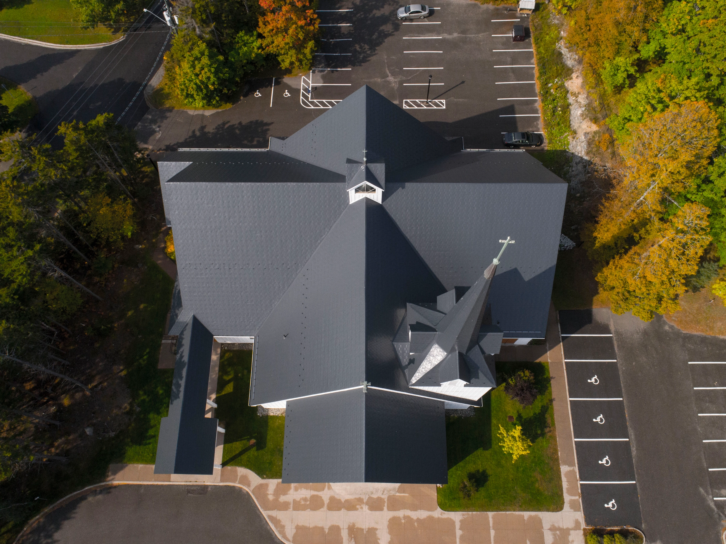 Deep Charcoal Interlock Slate aluminum roof on a church with a deep charcoal metal roof in a forested area, Rothesay, New Brunswick