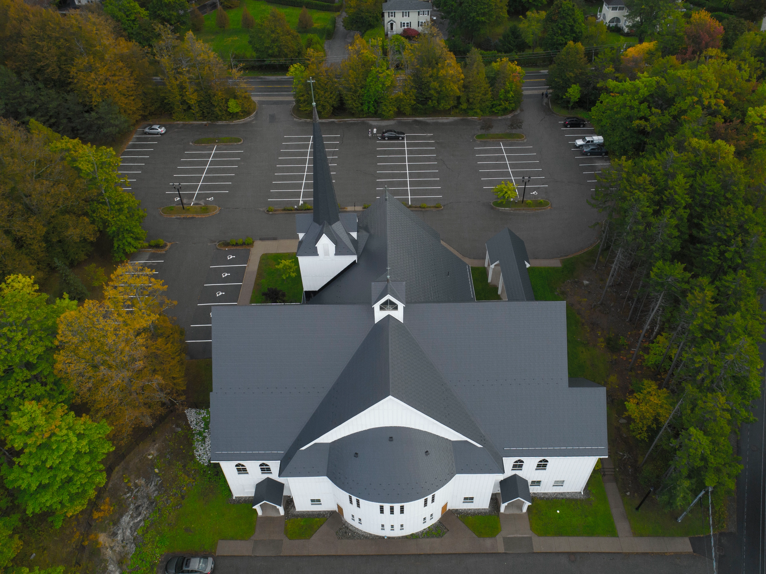 Deep Charcoal Interlock Slate aluminum roof on a white church with a metal roof among tall green trees, Rothesay, New Brunswick