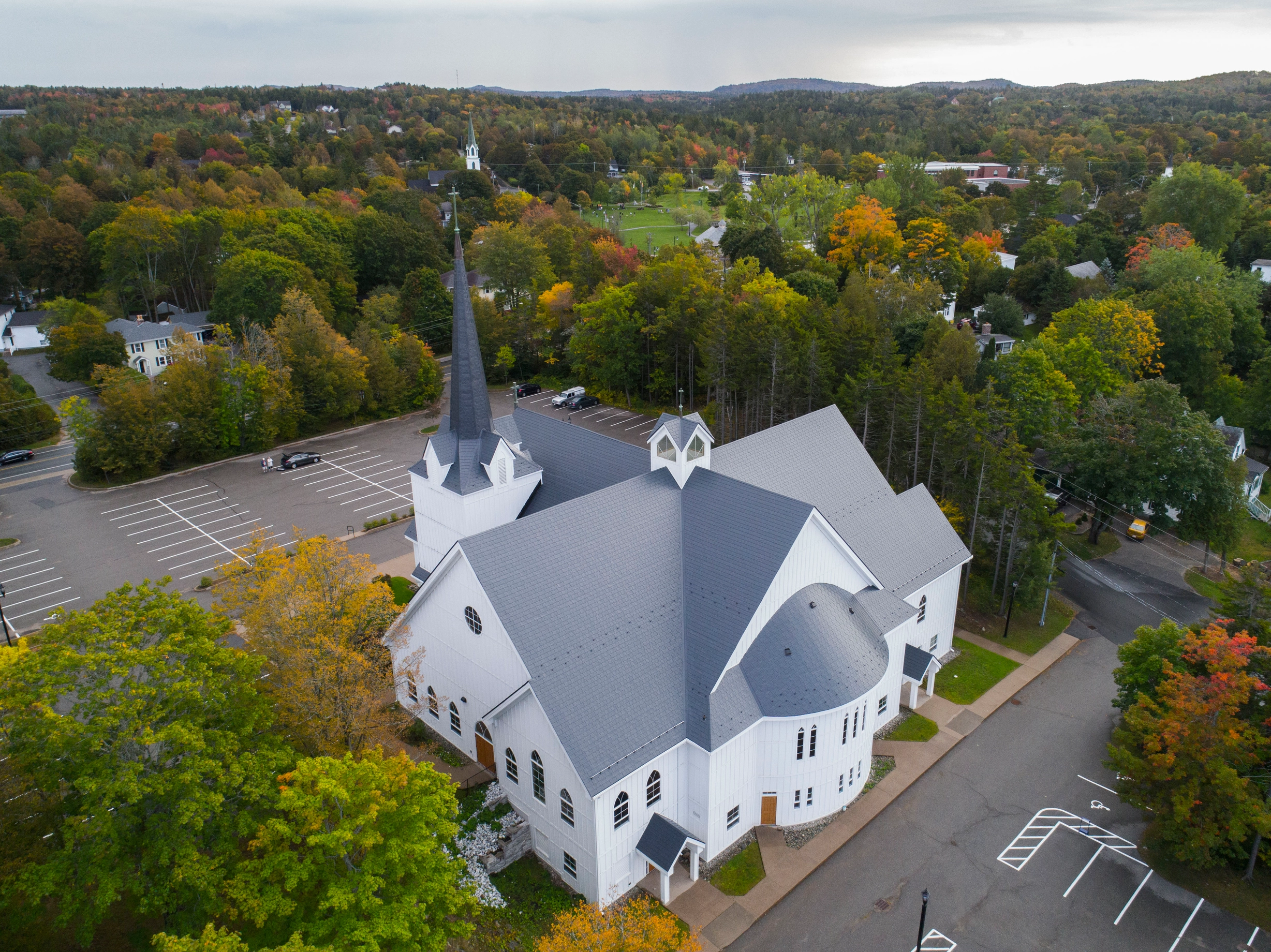 Deep Charcoal Interlock Slate aluminum roof on a white church with a grey metal roof in a wooded area, Rothesay, New Brunswick