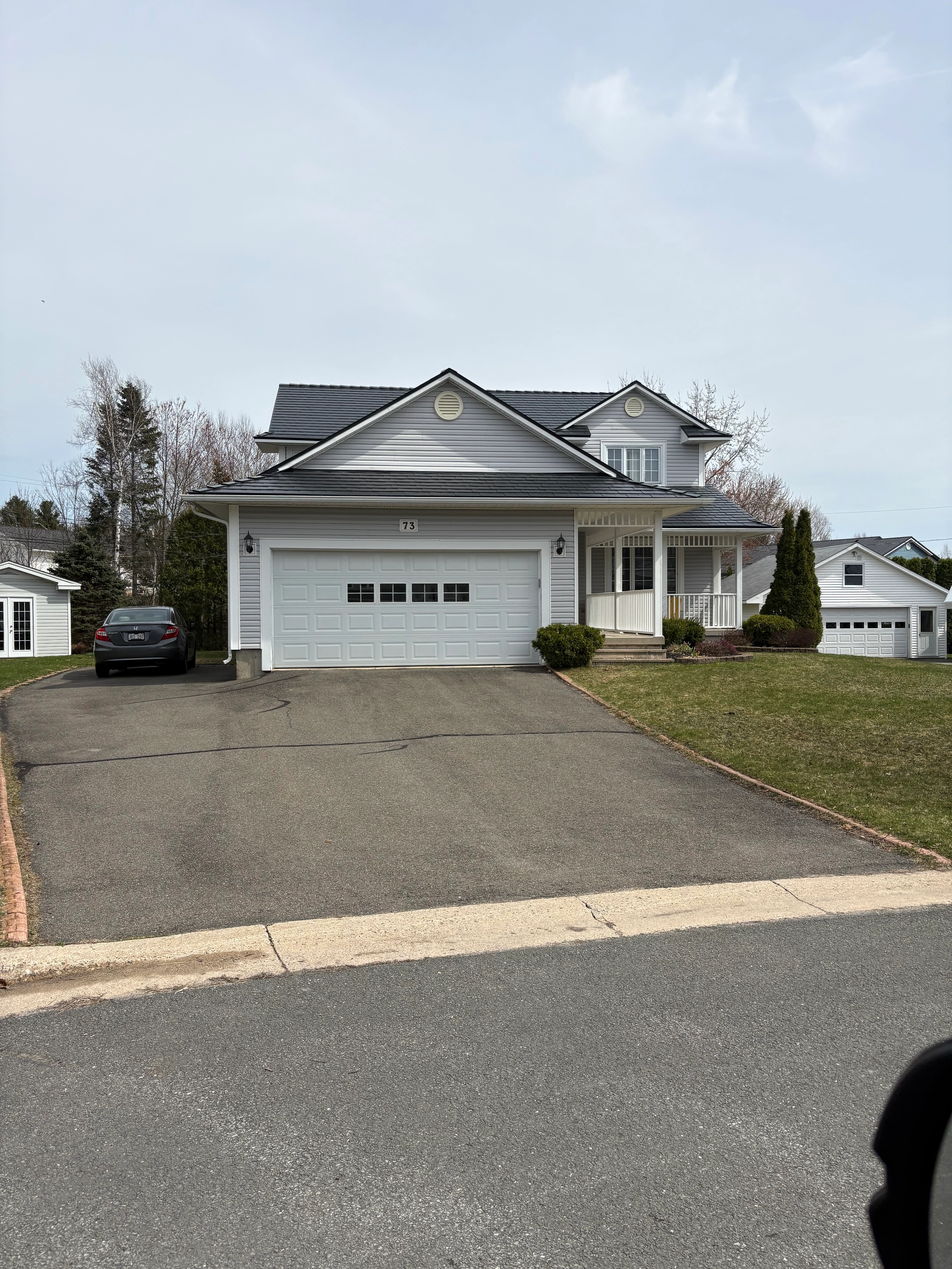 Black Interlock Slate aluminum roof on a white single-family home with a grey metal roof in a, Fredericton, New Brunswick