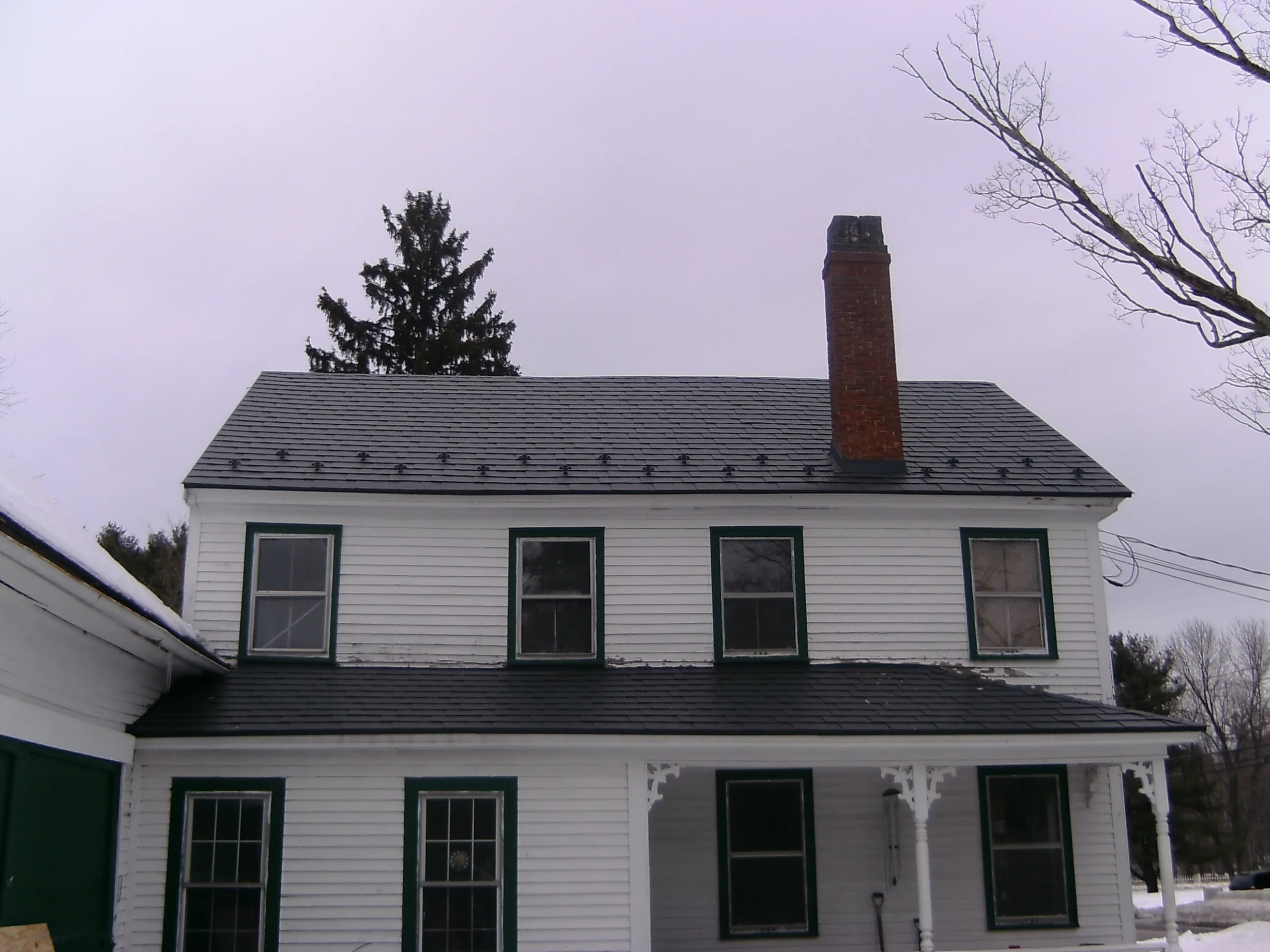 Charcoal Grey Interlock Slate aluminum roof on a white colonial home with a covered porch in a rural, Windham, New Hampshire