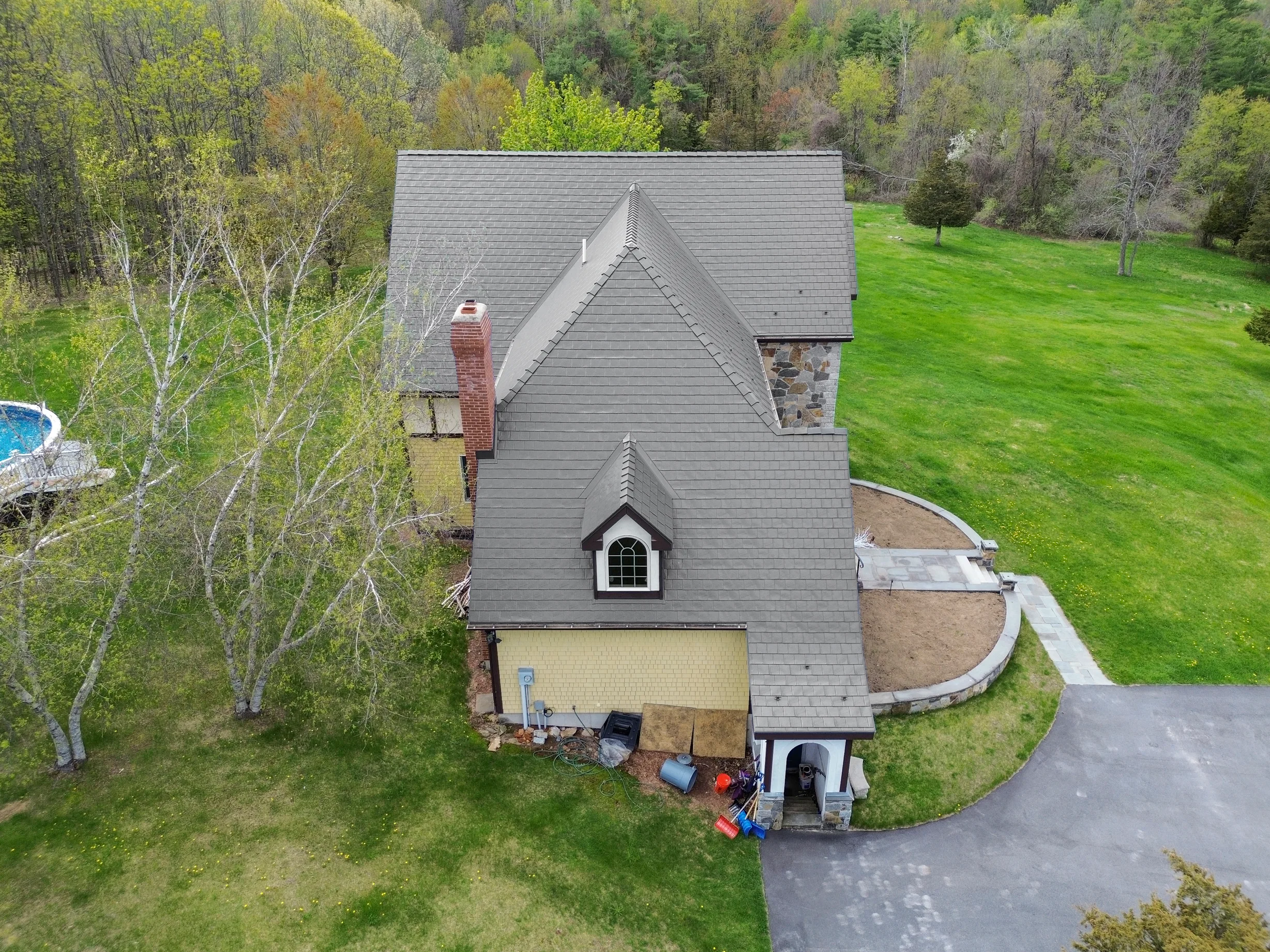 Deep Charcoal Interlock Slate aluminum roof on a colonial home with a grey roof in a forested setting, Madbury, New Hampshire