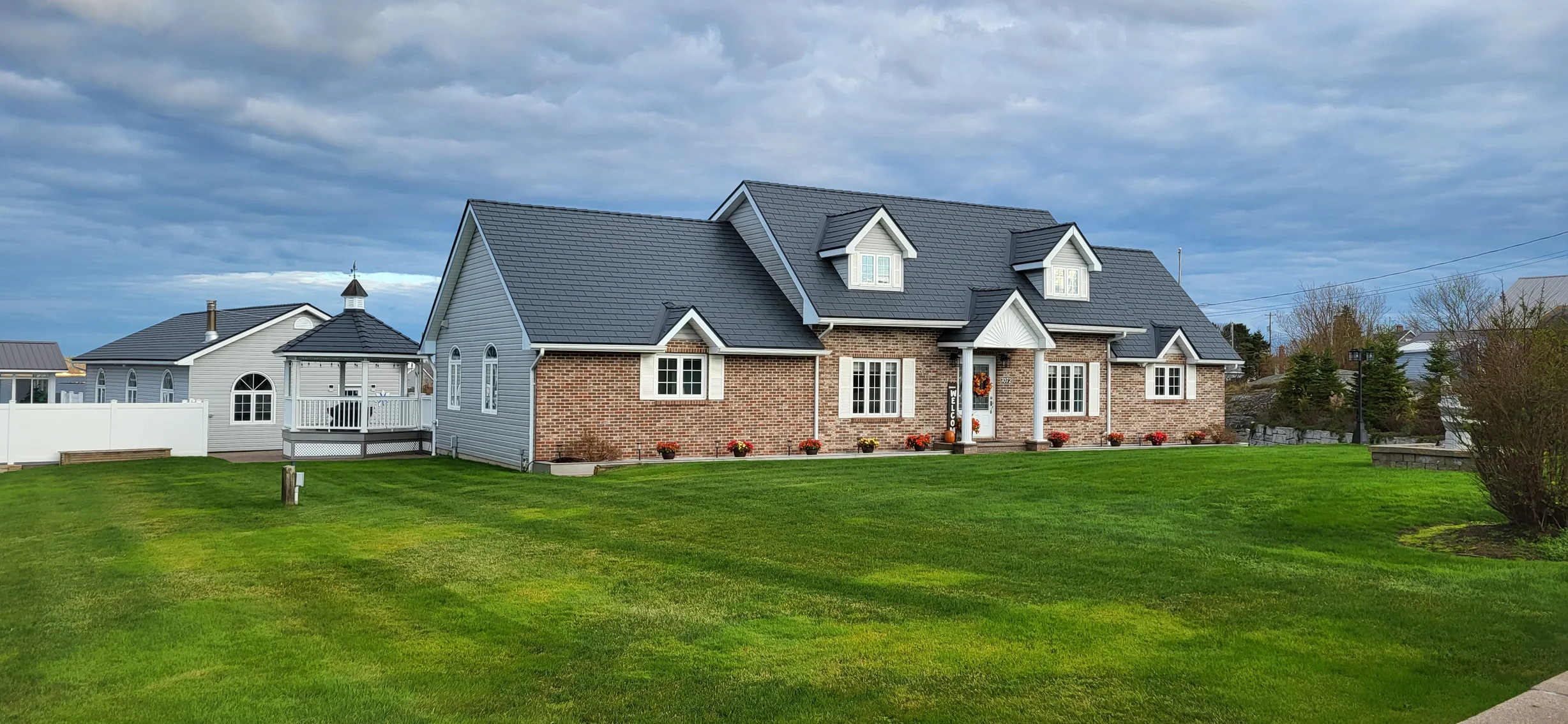 Deep Charcoal Interlock Cedar Shingle aluminum roof on a beige single-storey ranch with a metal roof in a rural, West Dover, Nova Scotia