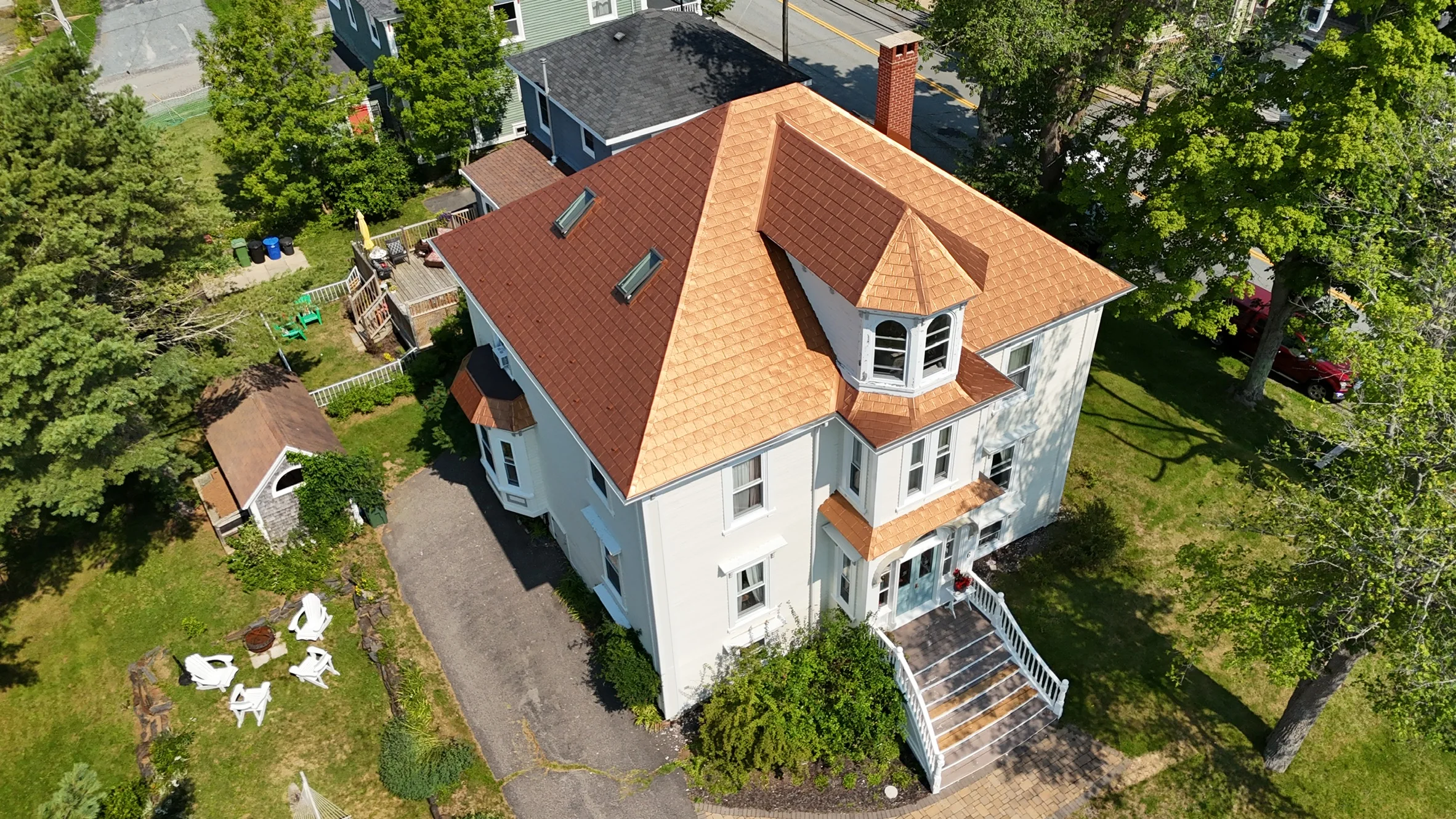 Aged Copper Interlock Slate aluminum roof on a white two-storey home with a copper metal roof in a, Lunenburg, Nova Scotia