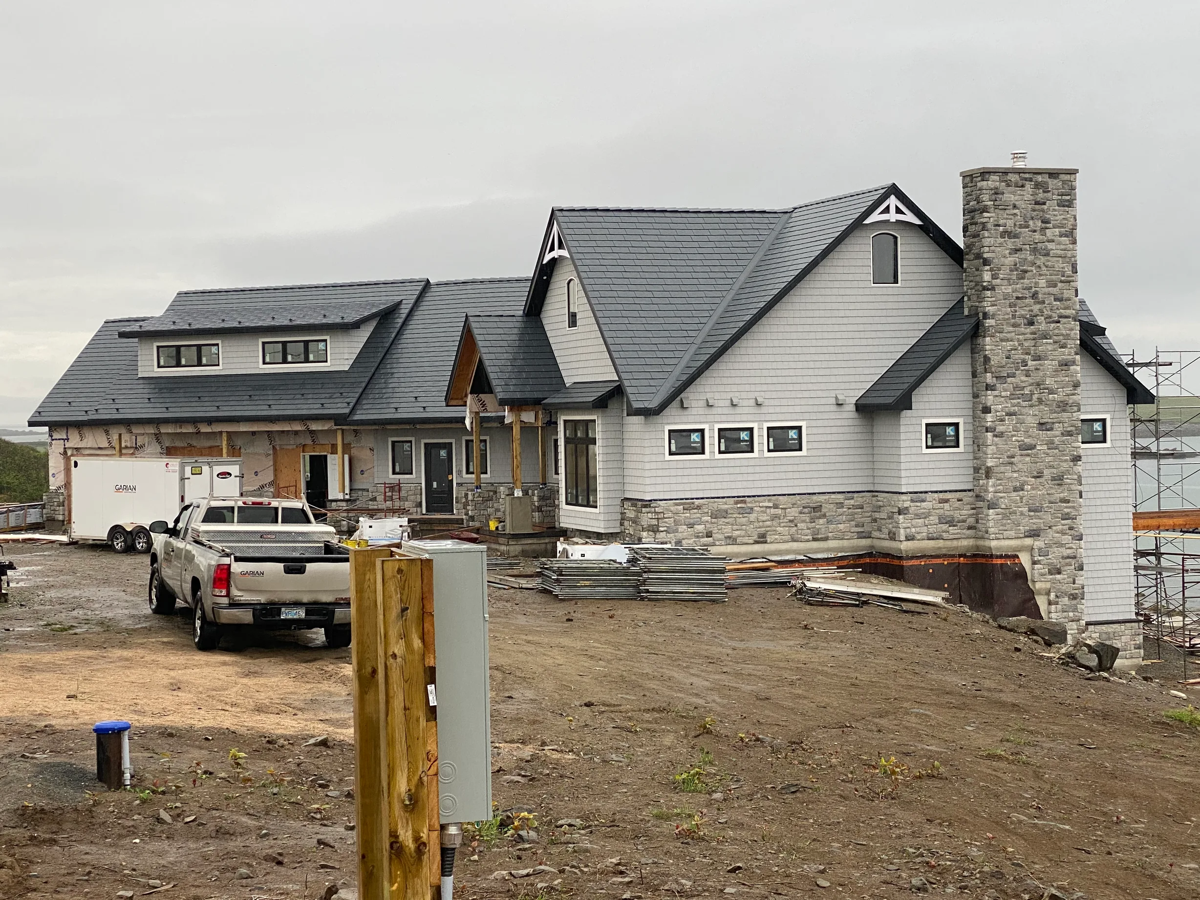 Deep Charcoal Interlock Slate aluminum roof being installed on the home, Sand Beach, Nova Scotia