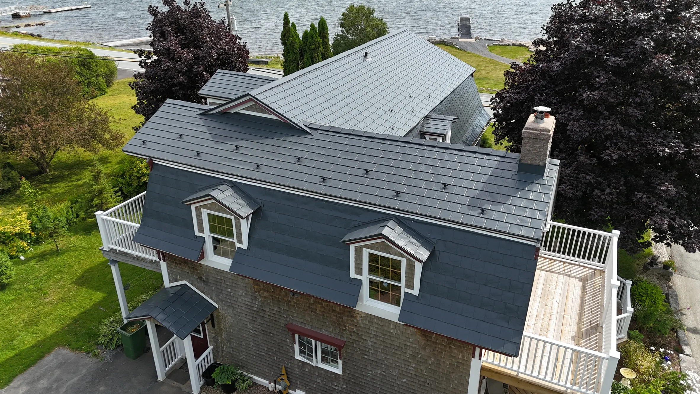 Deep Charcoal Interlock Slate aluminum roof on the home with roof louver and chimney, East LaHave, Nova Scotia