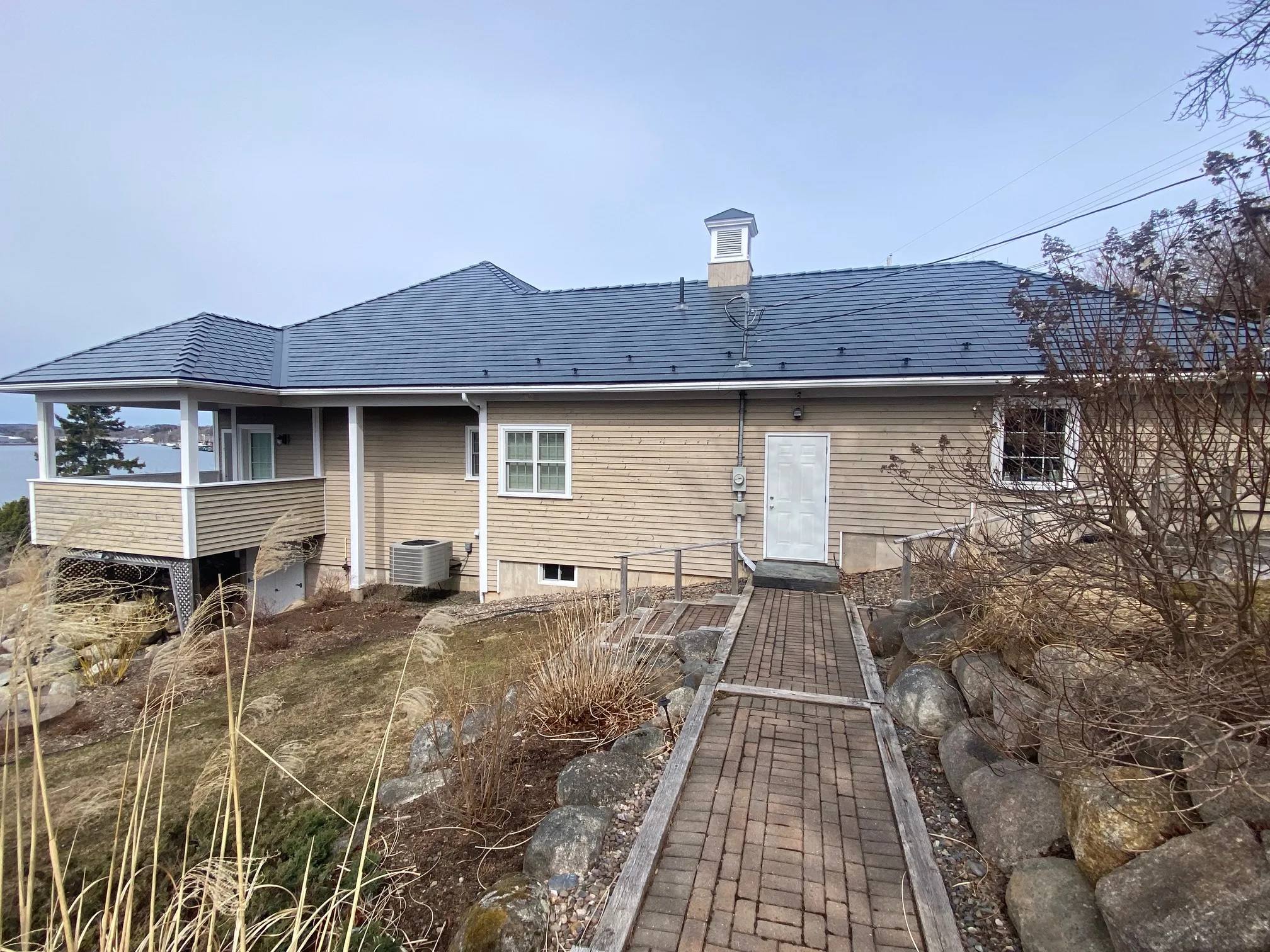 Deep Charcoal Interlock Slate aluminum roof on the home with chimney and roof louver, Lunenburg, Nova Scotia