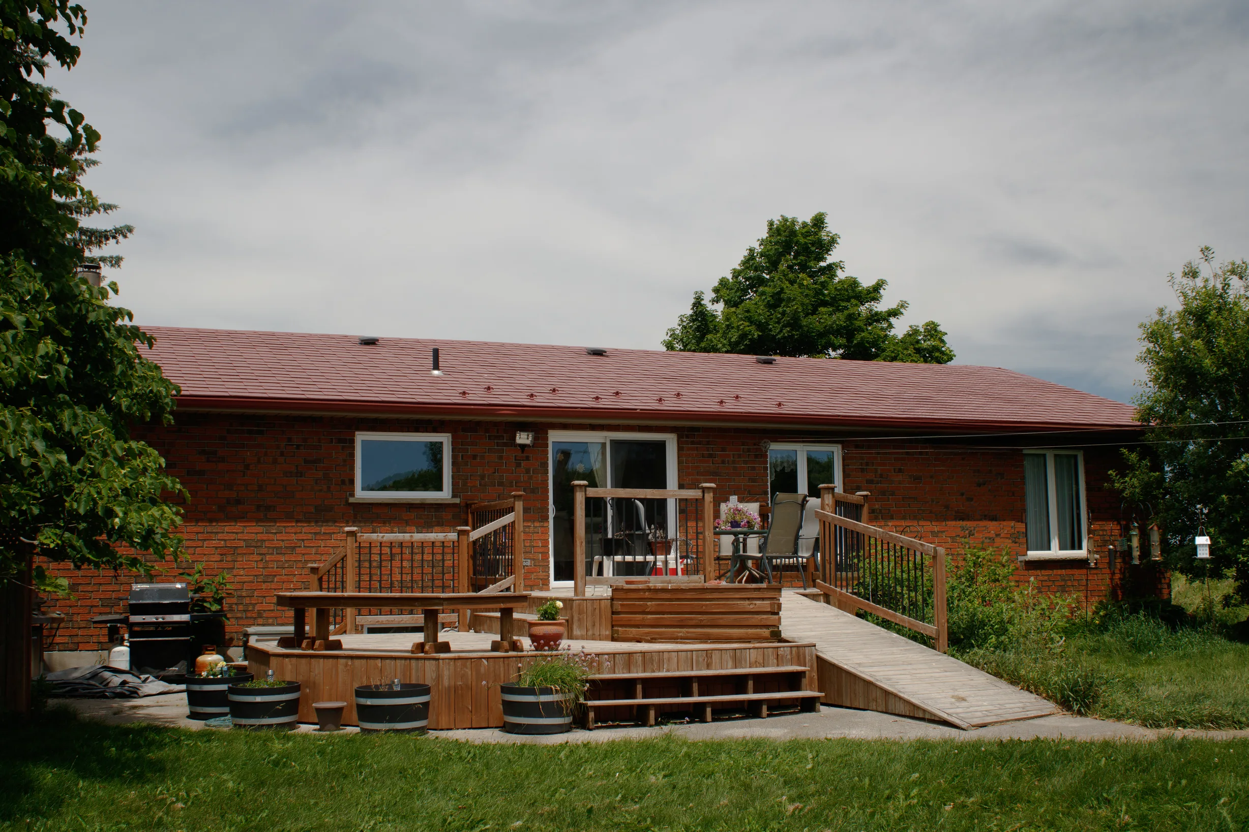 Tile Red Interlock Shingle aluminum roof on a red brick ranch with a brown roof and front porch, Orangeville, Ontario