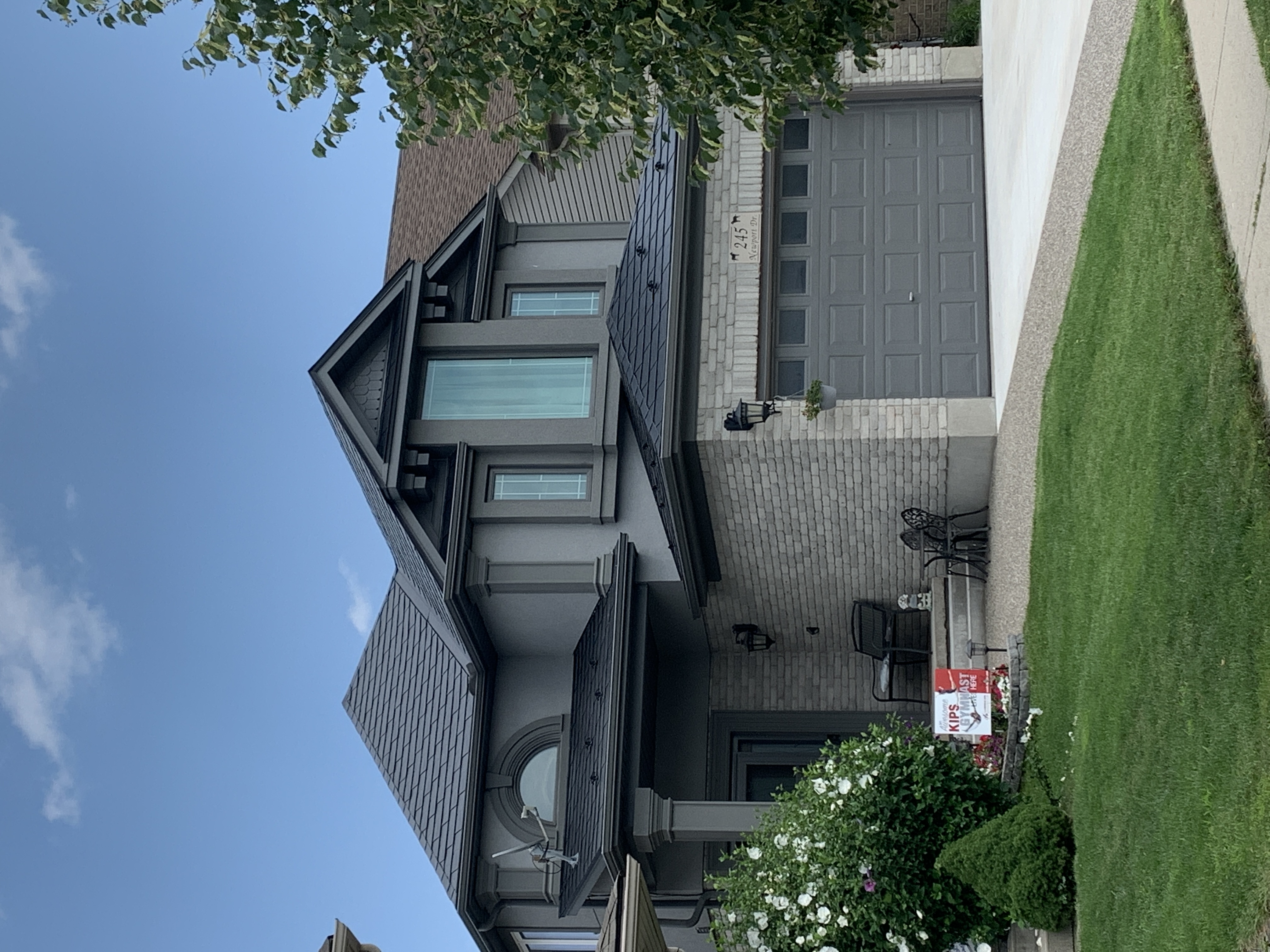 Two-storey Craftsman home in Cambridge ON with a black Interlock aluminum slate metal roof featuring complex multi-hip geometry and a front dormer.