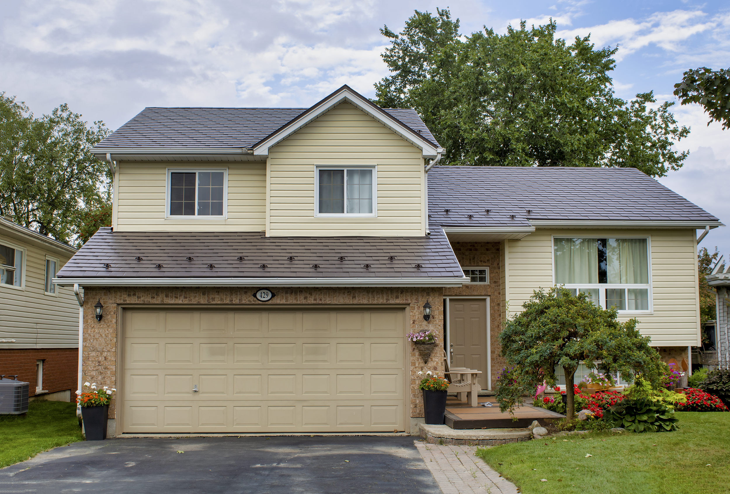 Two-storey suburban home in Shelburne ON with Interlock Tudor Brown aluminum slate metal roofing across multiple roof planes and gable.
