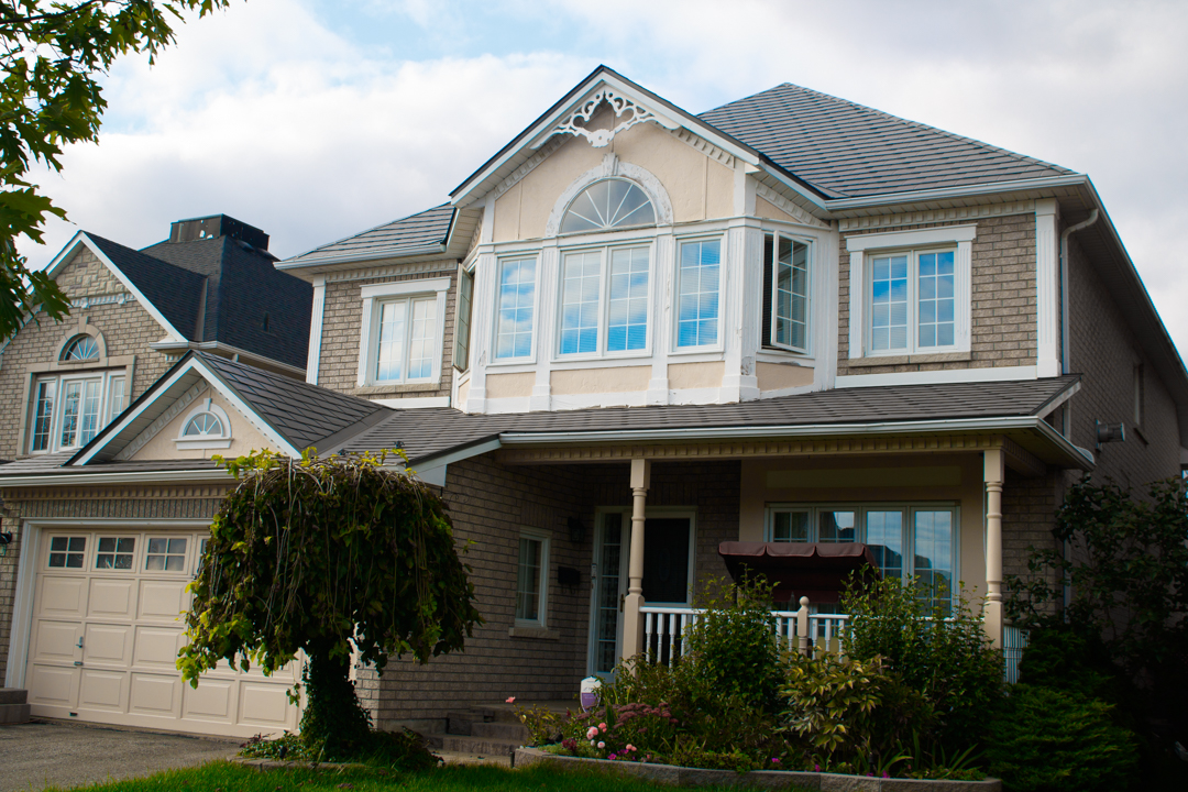Two-storey Victorian-style home in Ajax, ON featuring Interlock aluminum slate roofing in Musket Grey with complex multi-hip roof and decorative dormer.