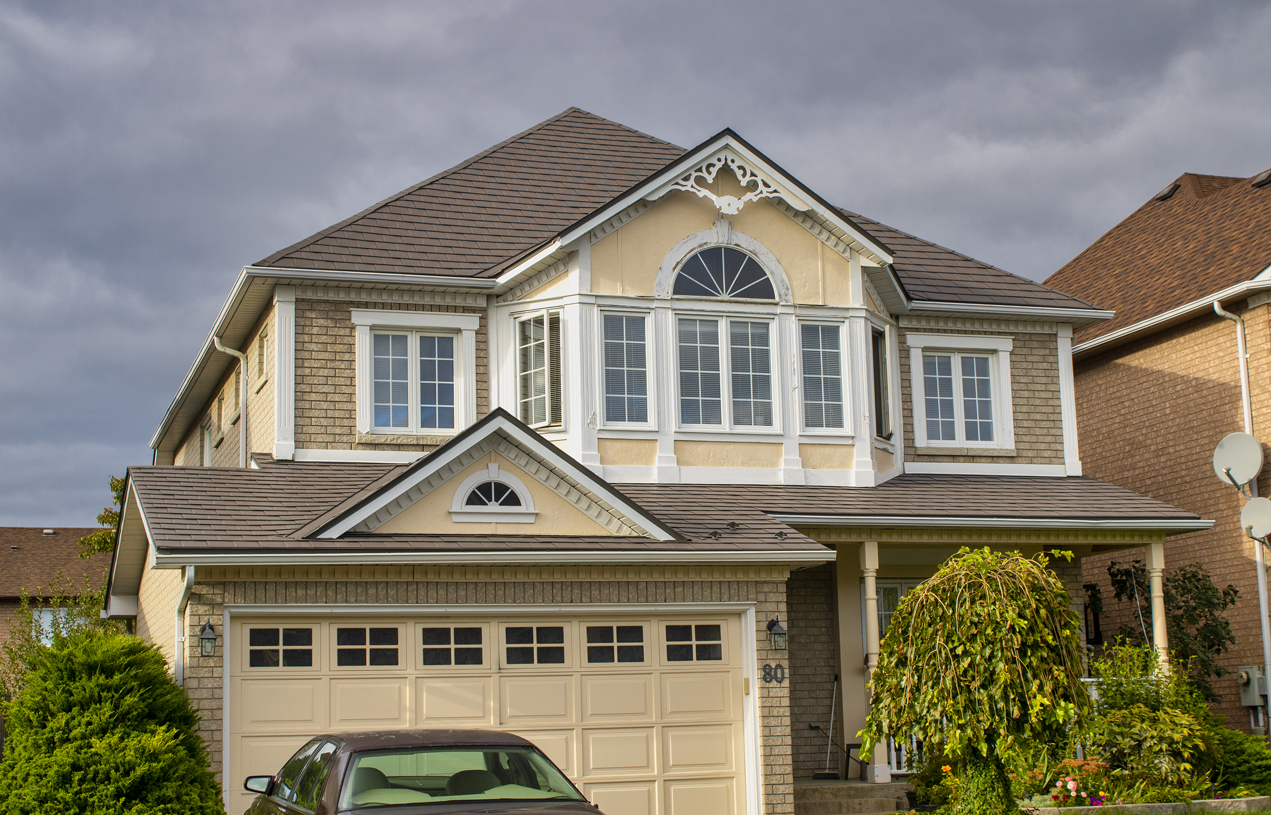 Two-storey colonial suburban home in Ajax ON with Interlock aluminum slate roof in Musket Grey featuring multi-hip complexity and decorative dormer gable.