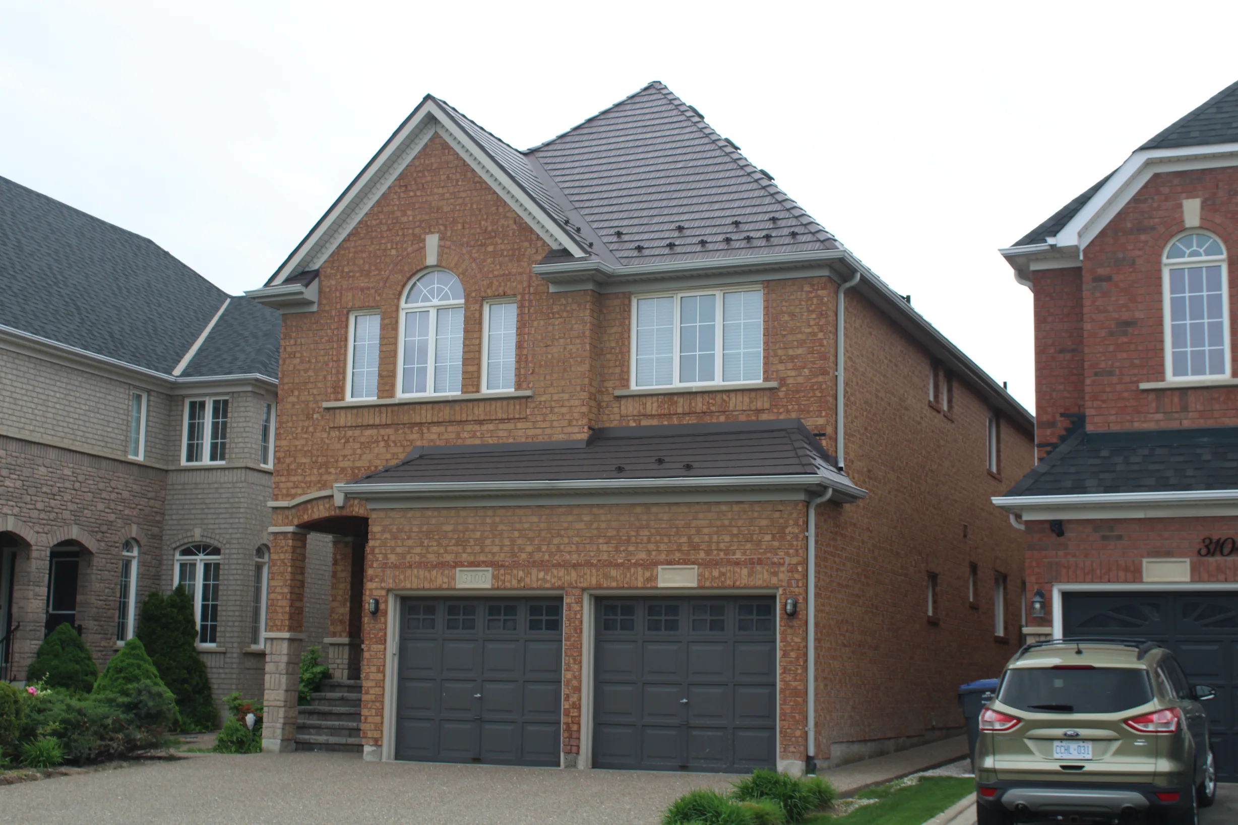 Tudor Brown Interlock Cedar Shingle aluminum roof on a brown two-storey home with dormers in an urban setting, Mississauga, Ontario