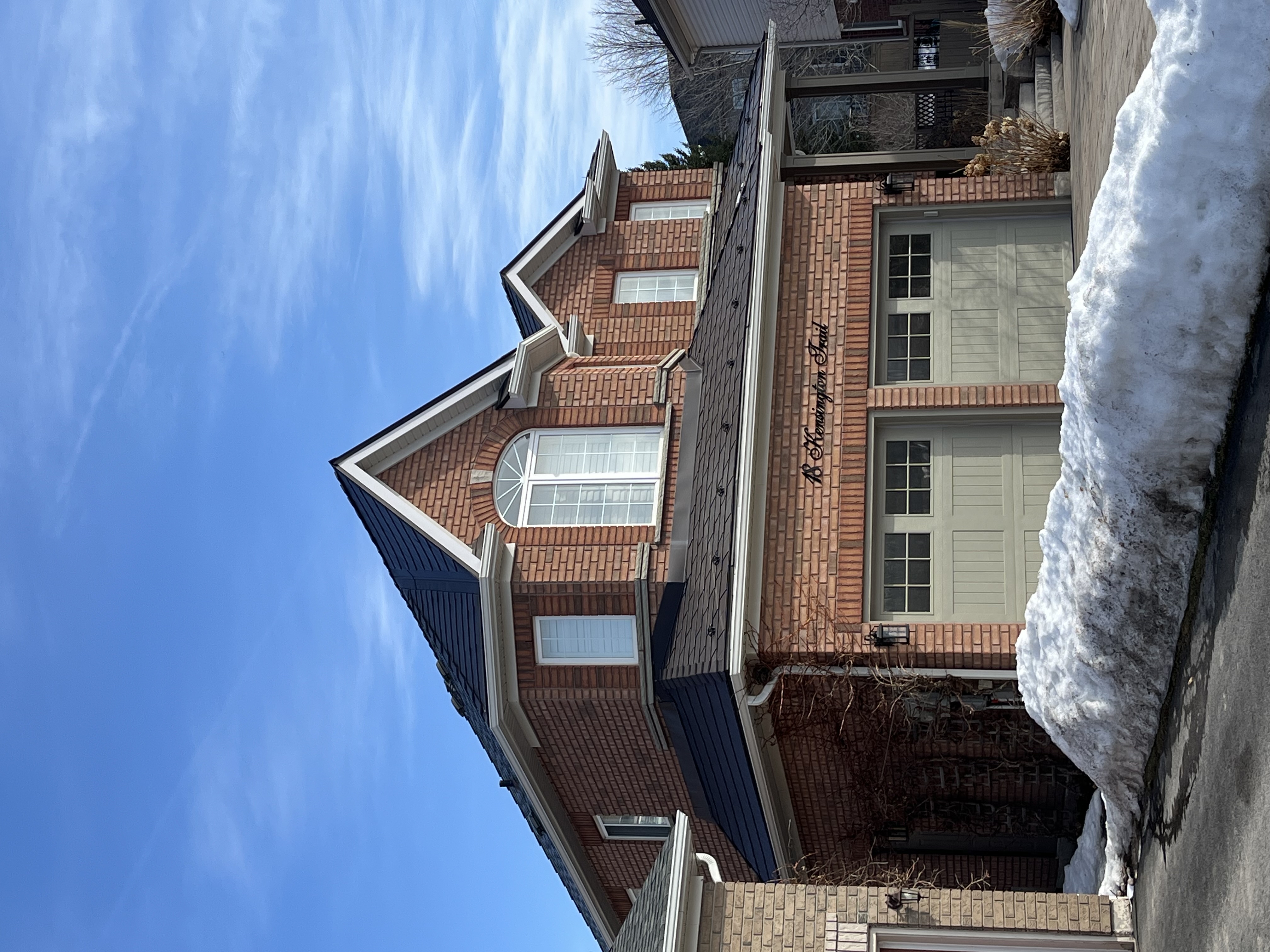 Two-storey brick Colonial home in Barrie, ON featuring Interlock Tudor Brown aluminum slate roofing with complex multi-hip profile and dormers.
