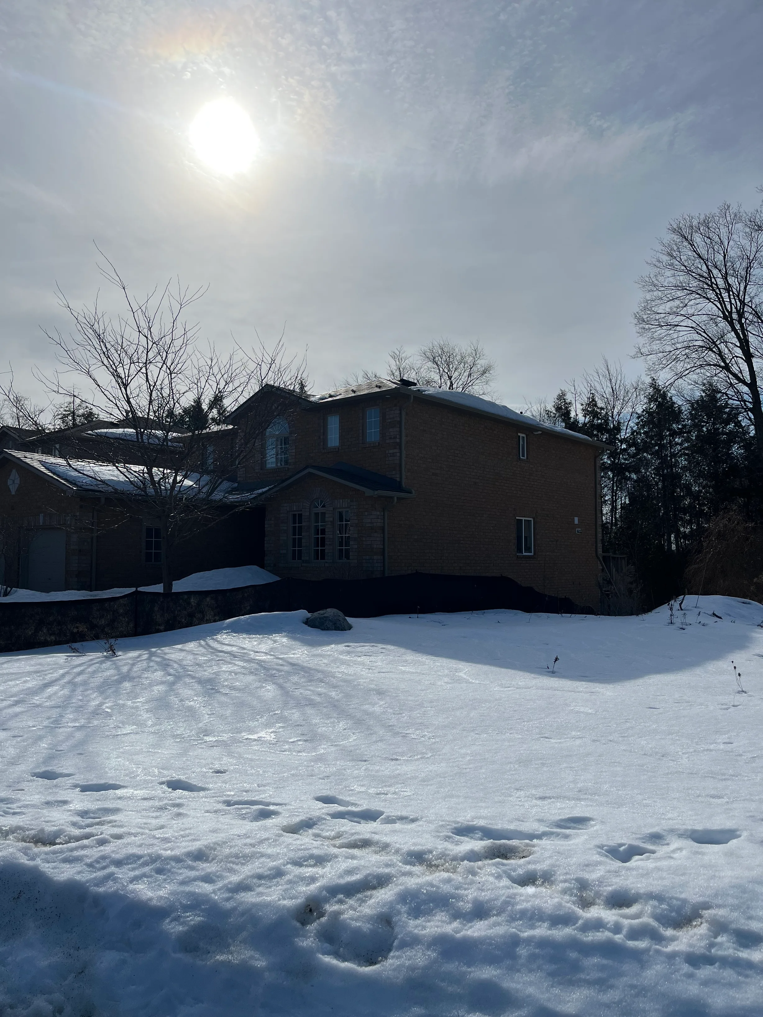 Musket Grey Interlock Slate aluminum roof on a two-storey home with dormers among tall trees, Barrie, Ontario