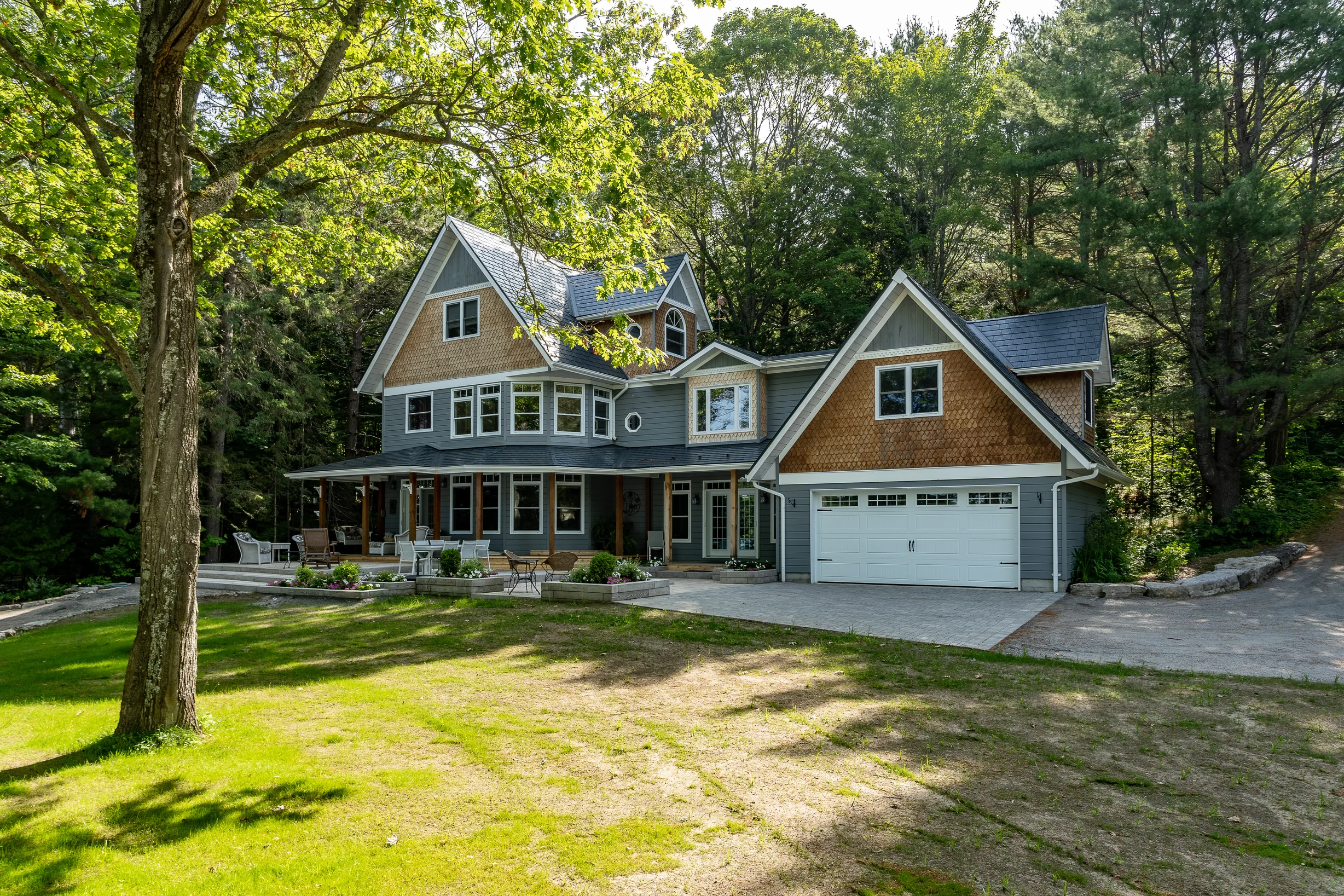 Deep Charcoal Interlock Slate aluminum roof on a two-storey home with dormers in a forest clearing, Algonquin Highlands, Ontario