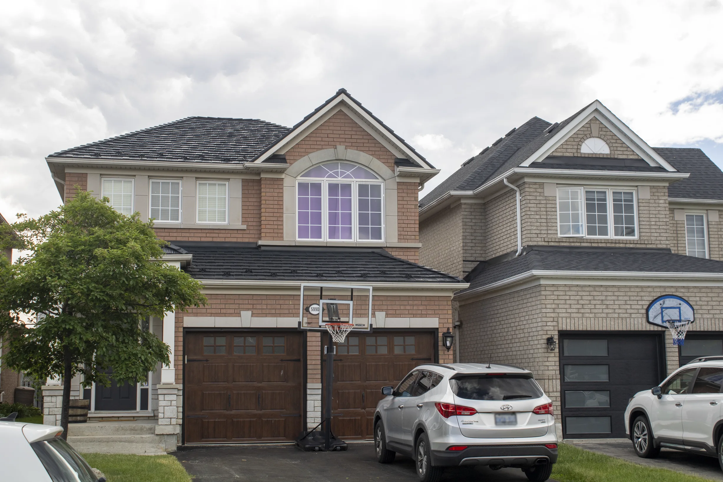 Black Interlock Shake aluminum roof on a beige single-family home with a metal roof in a suburban, Mississauga, Ontario