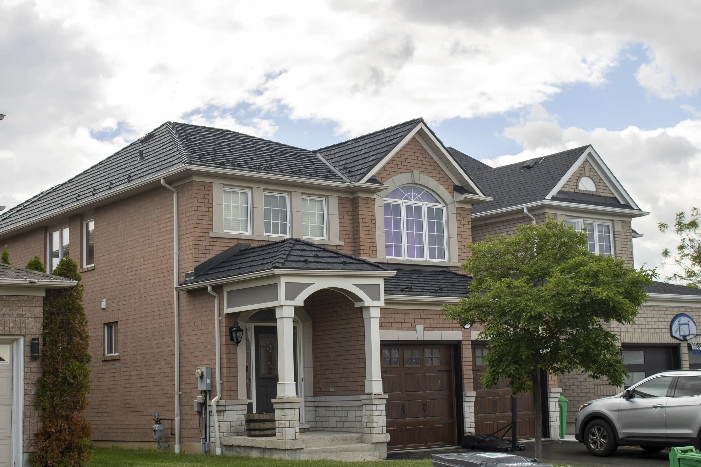 Black Interlock Shake aluminum roof on a two-storey brick home with a metal roof in a suburban, Mississauga, Ontario