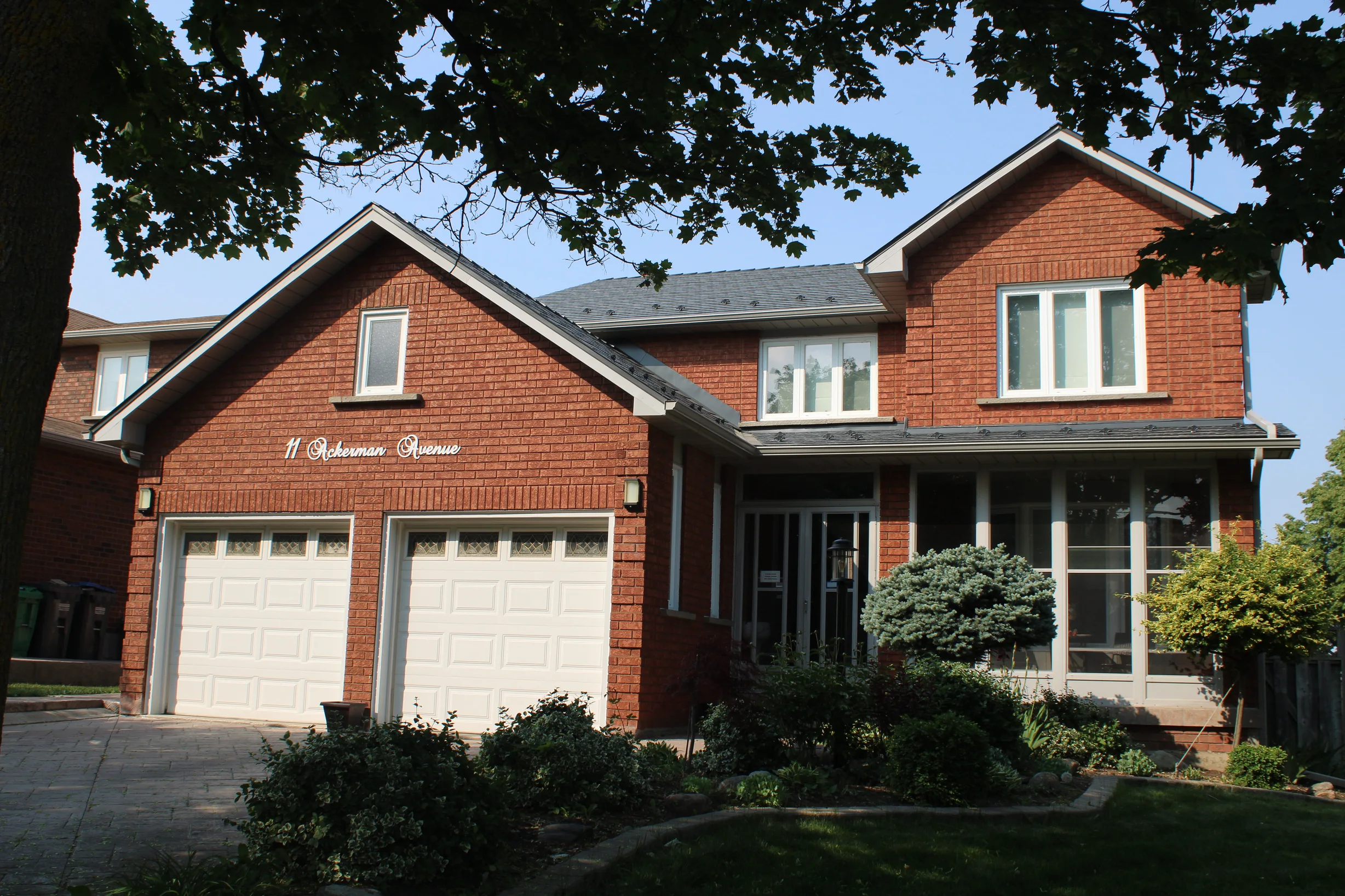 Deep Charcoal Interlock Cedar Shingle aluminum roof on a red brick two-storey home with dormers and a grey metal, Brampton, Ontario
