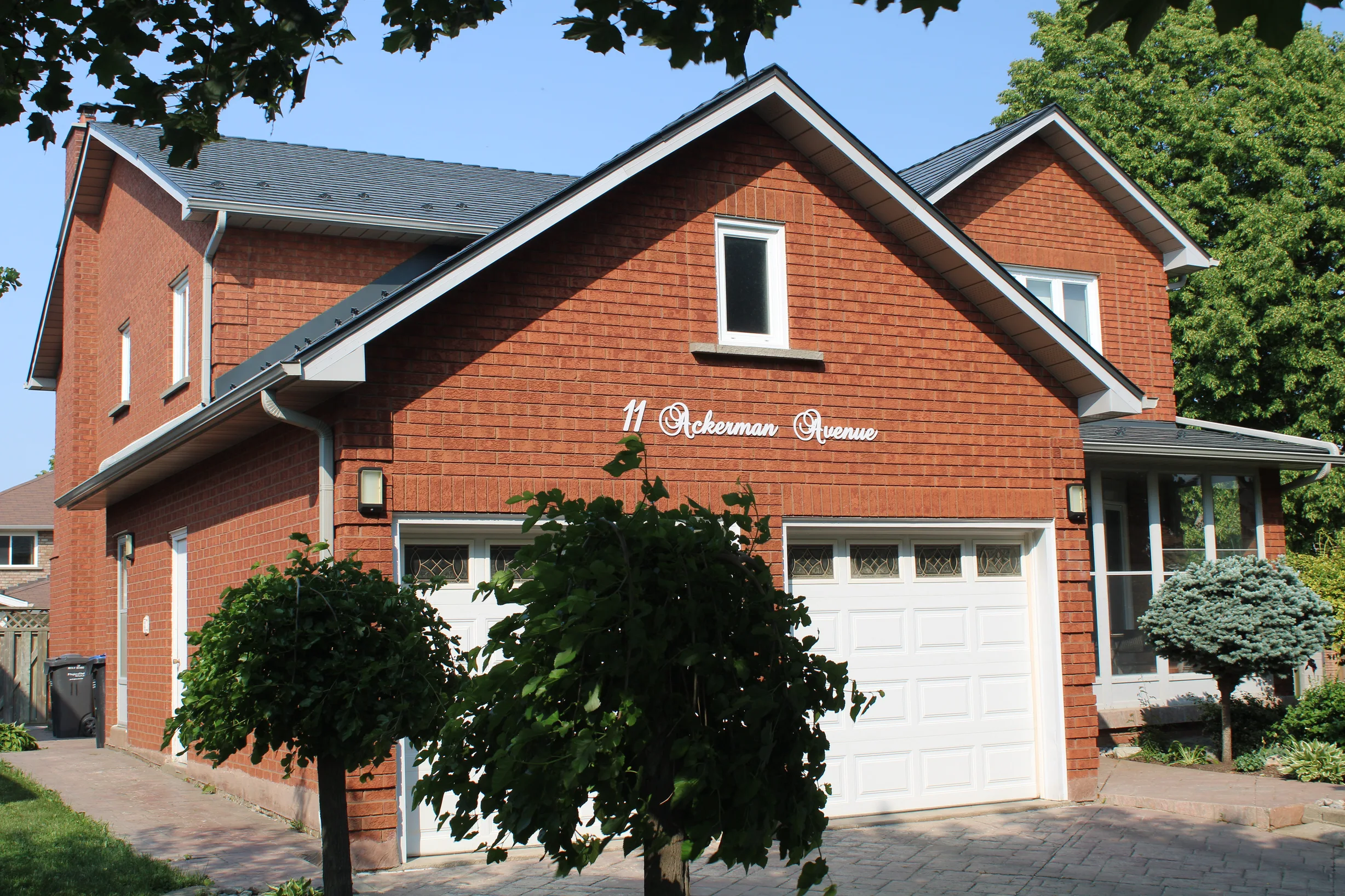 Deep Charcoal Interlock Cedar Shingle aluminum roof on a brick two-storey home with a garage and dormers in a, Brampton, Ontario