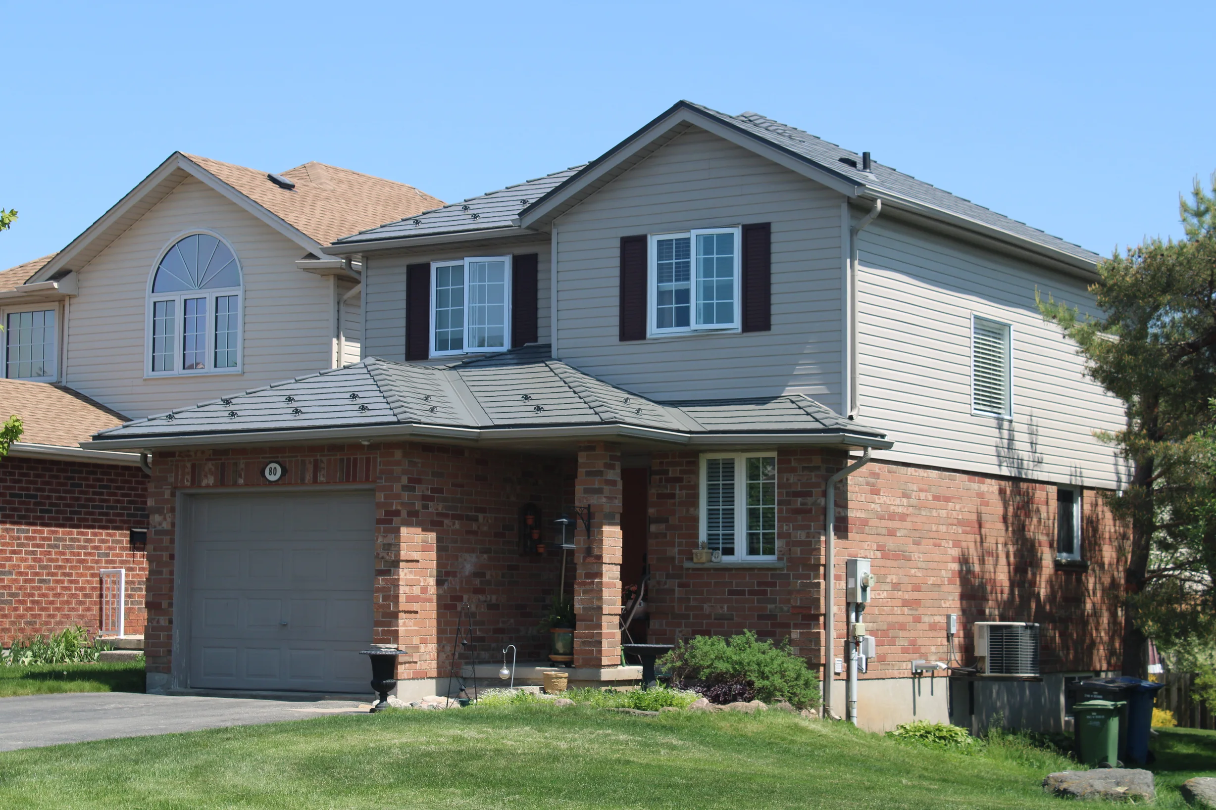 Musket Grey Interlock Cedar Shingle aluminum roof on a grey two-storey home with a metal roof in a suburban, Guelph, Ontario