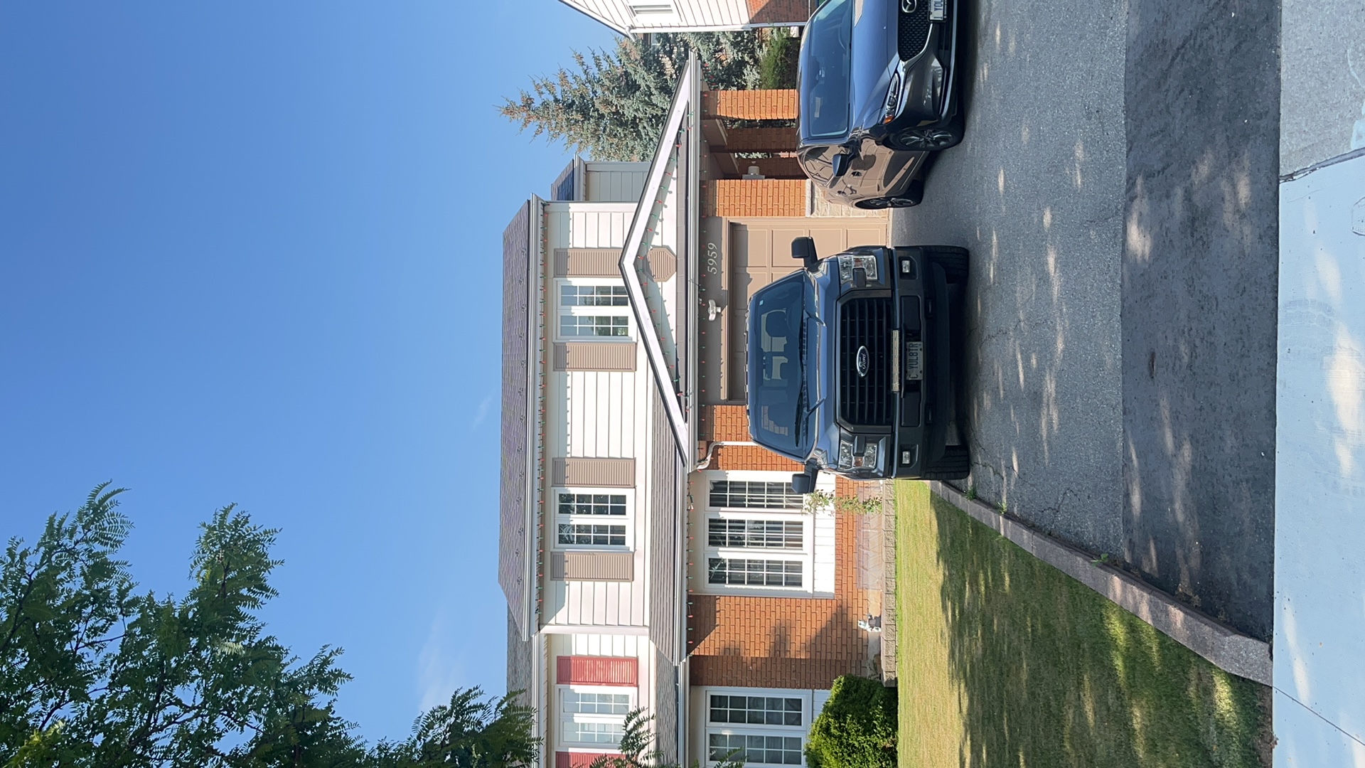 Two-storey Colonial home in Mississauga with Interlock Musket Grey aluminum slate metal roofing, brick facade, and attached garage.