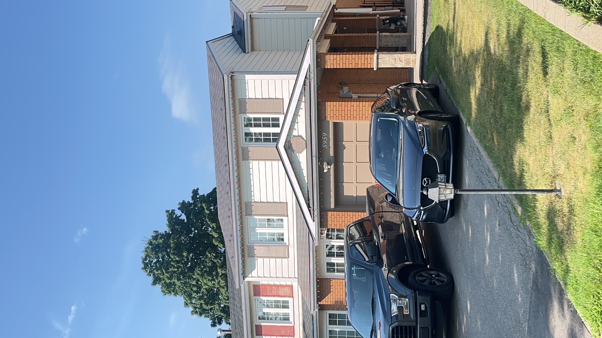 Front elevation of a two-storey townhome in Mississauga with Interlock Musket Grey aluminum slate metal roofing on a multi-plane gabled roof.