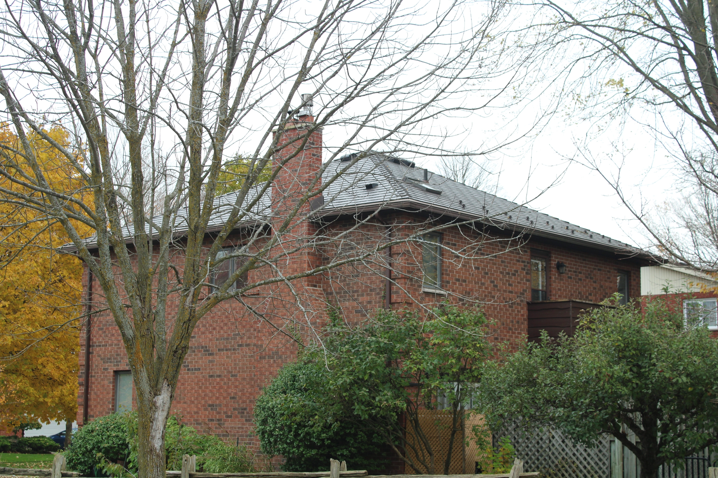 Tudor Brown Interlock Cedar Shingle aluminum roof on a red brick home with a brown metal roof in a residential, Waterloo, Ontario
