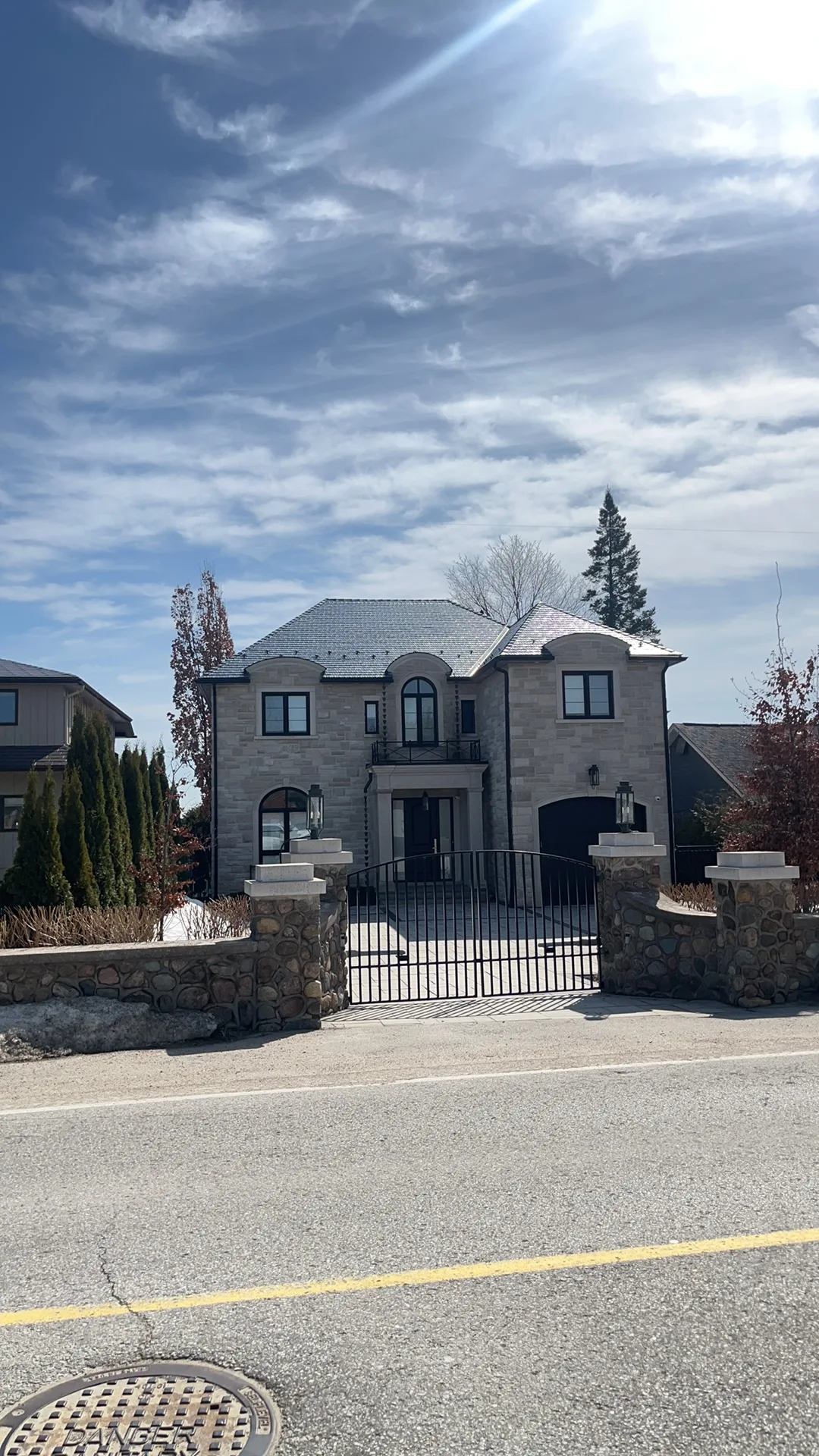 Tudor Brown Interlock Slate aluminum roof on a two-storey Tudor-style home with a slate roof near a lake, Innisfil, Ontario