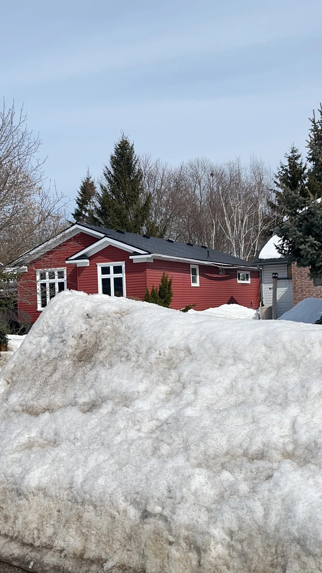 Black Interlock Slate aluminum roof on a red one-storey ranch home with a black metal roof in a, Orillia, Ontario