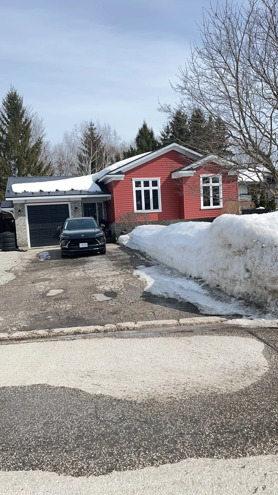 Black Interlock Slate aluminum roof on a red home with a metal roof in a snowy forest, Orillia, Ontario