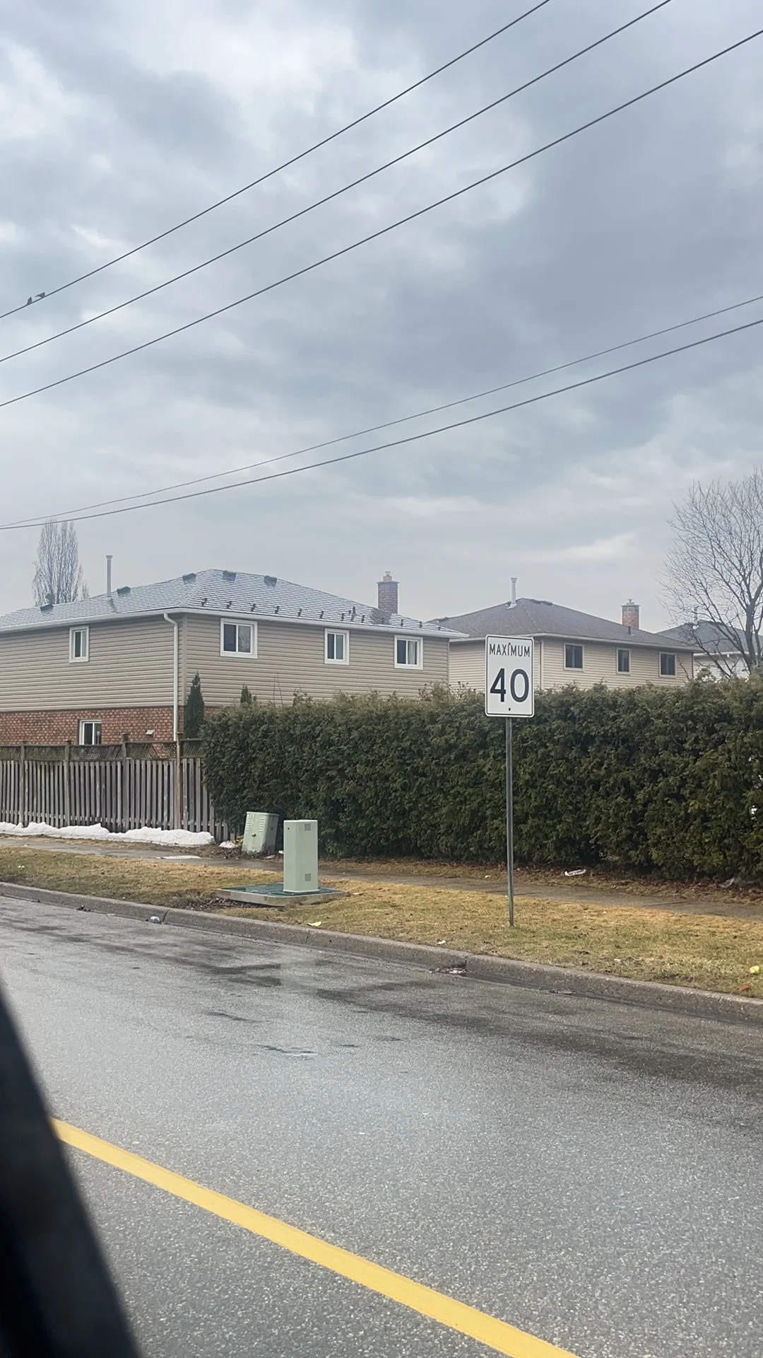 Tudor Brown Interlock Slate aluminum roof being installed on a two-storey home with brick accents in a suburban, Burlington, Ontario