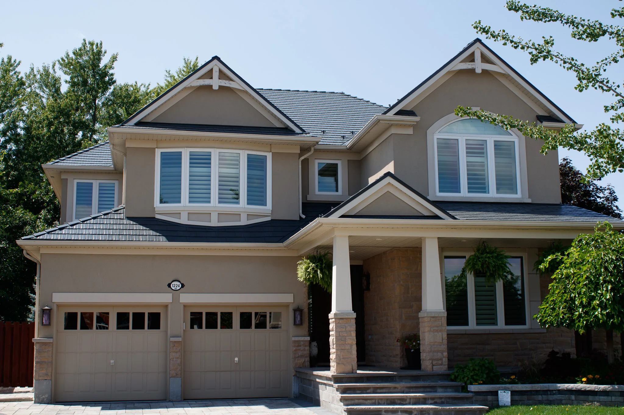 Deep Charcoal Interlock Cedar Shingle aluminum roof on a beige two-storey home with dormers among tall trees, Milton, Ontario