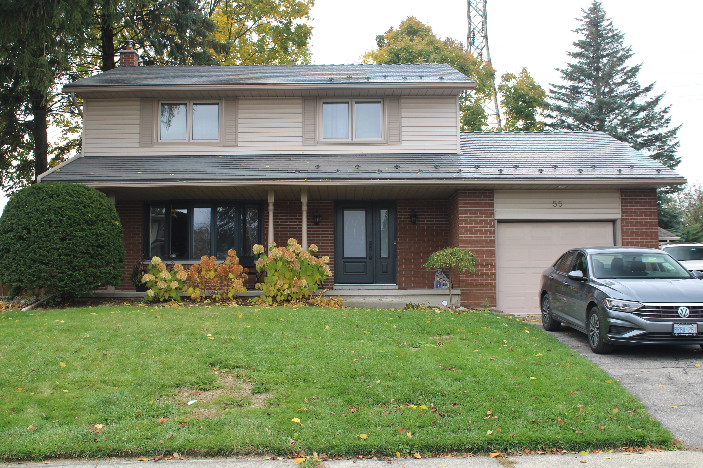 Musket Grey Interlock Cedar Shingle aluminum roof on a two-storey colonial home with a red brick facade and a, Kitchener, Ontario