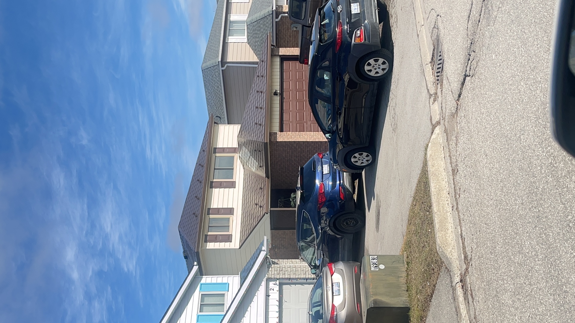 Two-storey suburban home in Bradford, ON with Interlock Colonial Brown aluminum slate metal roofing on a multi-hip roof, viewed from the street.