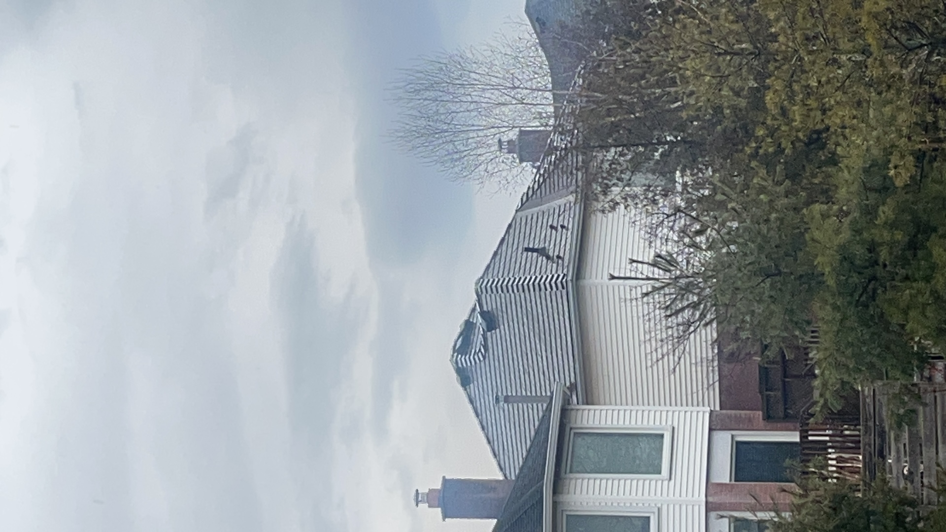 Colonial-style home in Burlington ON with Interlock Colonial Brown cedar shingle aluminum metal roofing on a multi-hip complex roof, viewed from rear-left elevation.