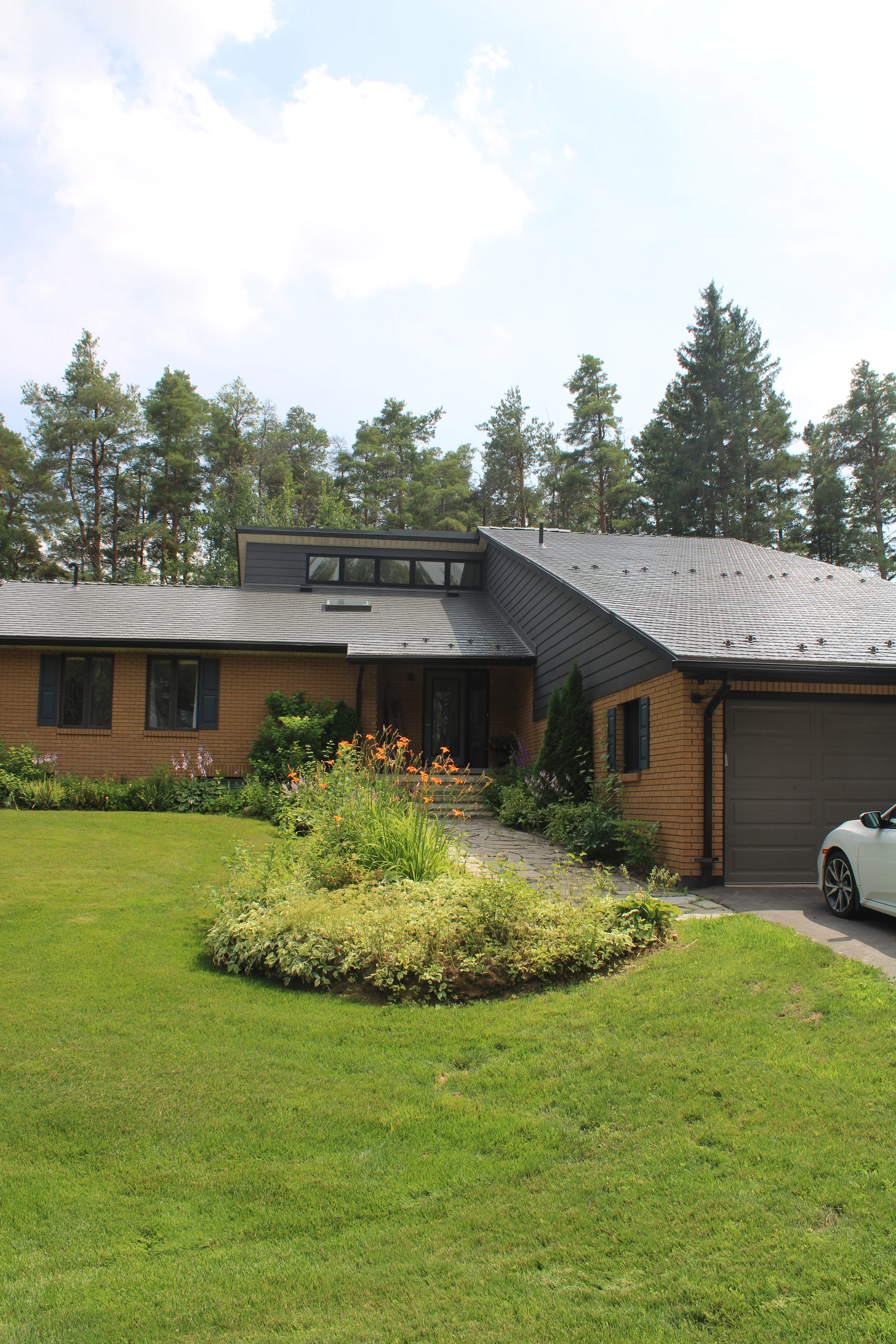 Musket Grey Interlock Cedar Shingle aluminum roof on a Musket Grey metal roof on a ranch home in a forested area, Mono, Ontario