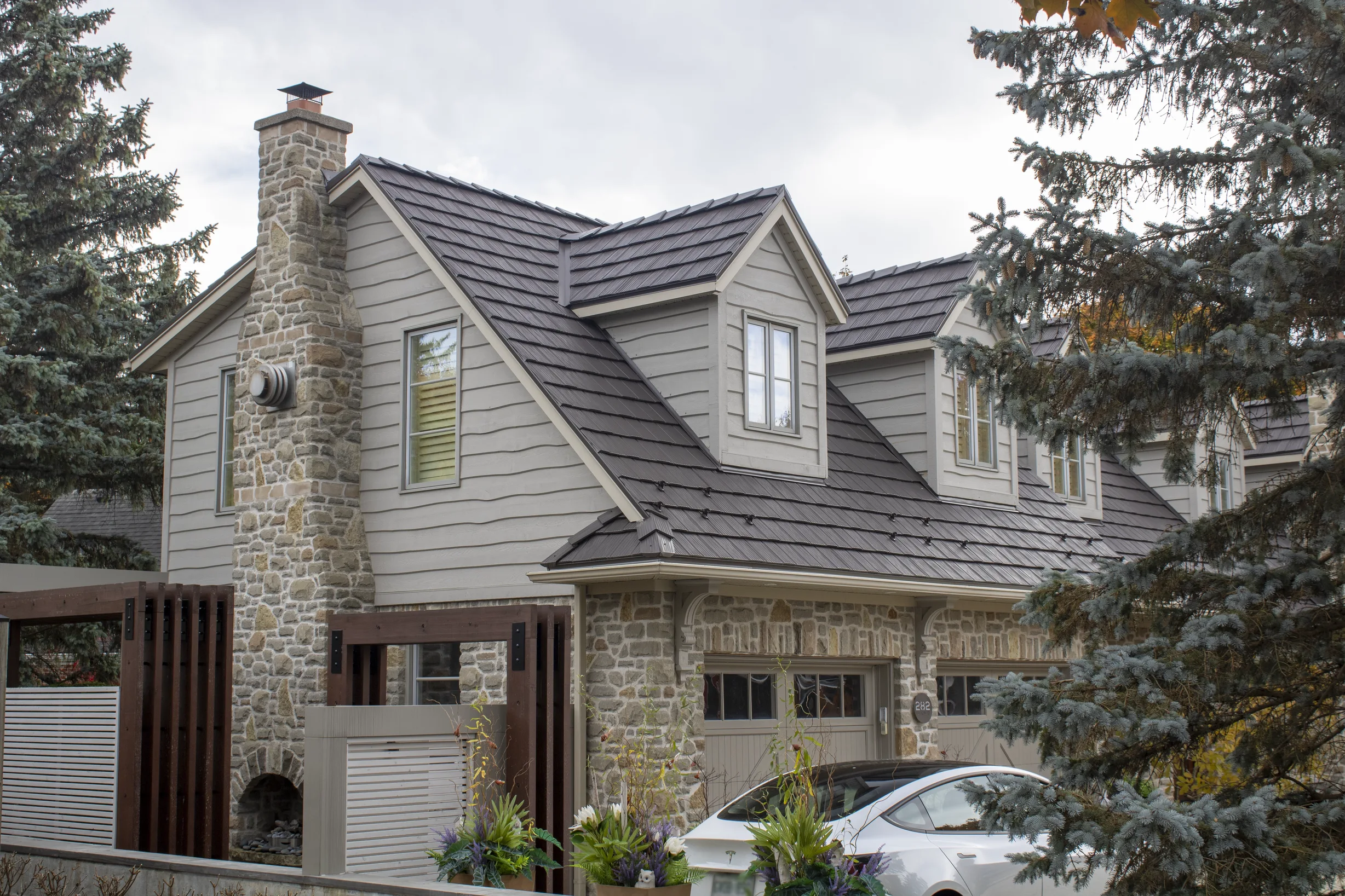 Tudor Brown Interlock Shake aluminum roof on a two-storey Tudor home with dormers in a neighbourhood, Waterloo, Ontario